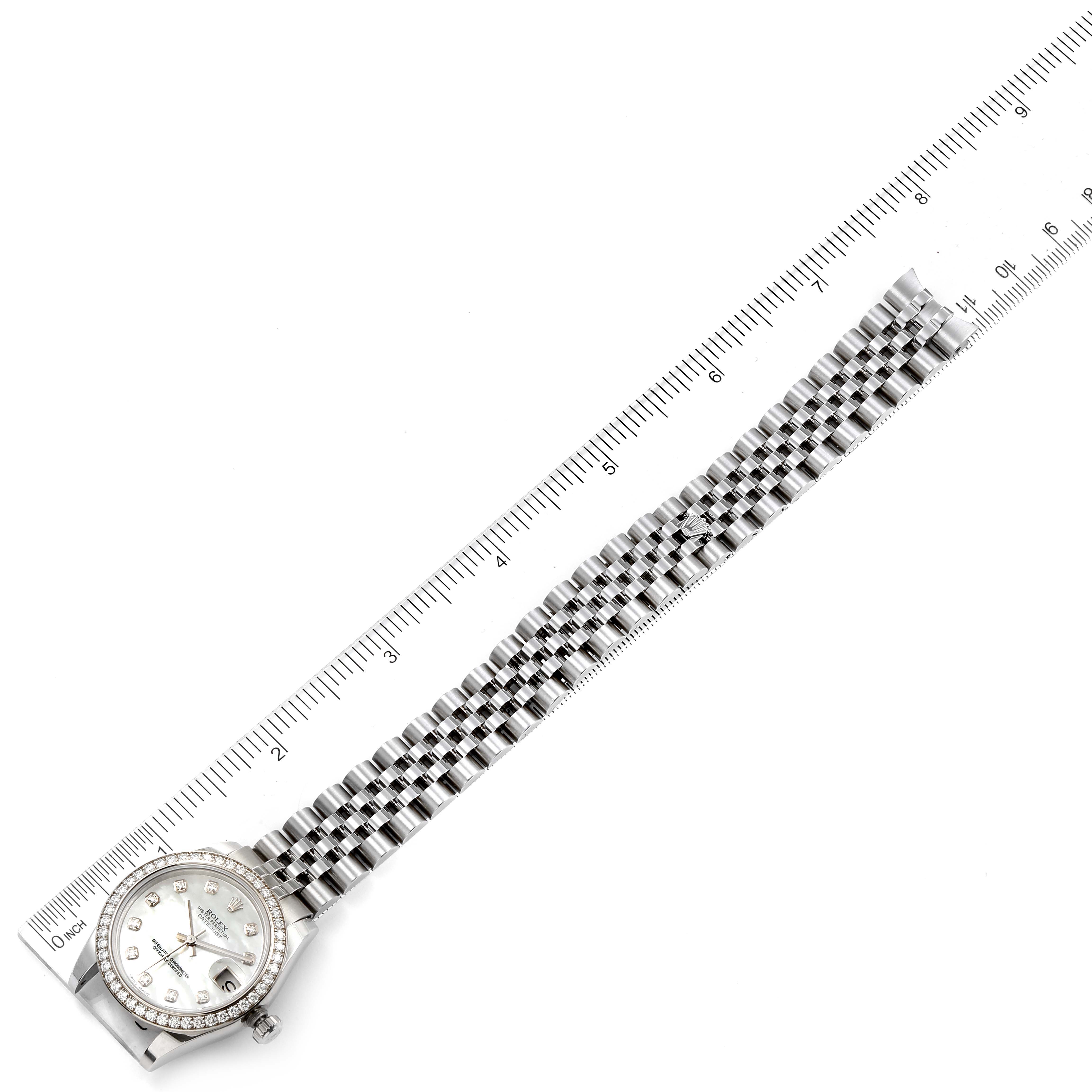 The Rolex Mid-Size 178384 Women
s Stainless Steel Mother of Pearl Dial 178384 Women
s Stainless Steel Mother of Pearl Dial watch is shown from a top-down angle featuring the face, bezel, and bracelet, next to a ruler for scale.