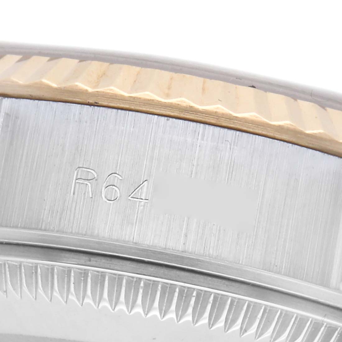 The image shows the side view of a Rolex Datejust 69173 Women's Steel and Gold (two tone) Champagne Dial 69173 Women's Steel and Gold (two tone) Champagne Dial watch, focusing on its fluted bezel and engraved edge of the case.