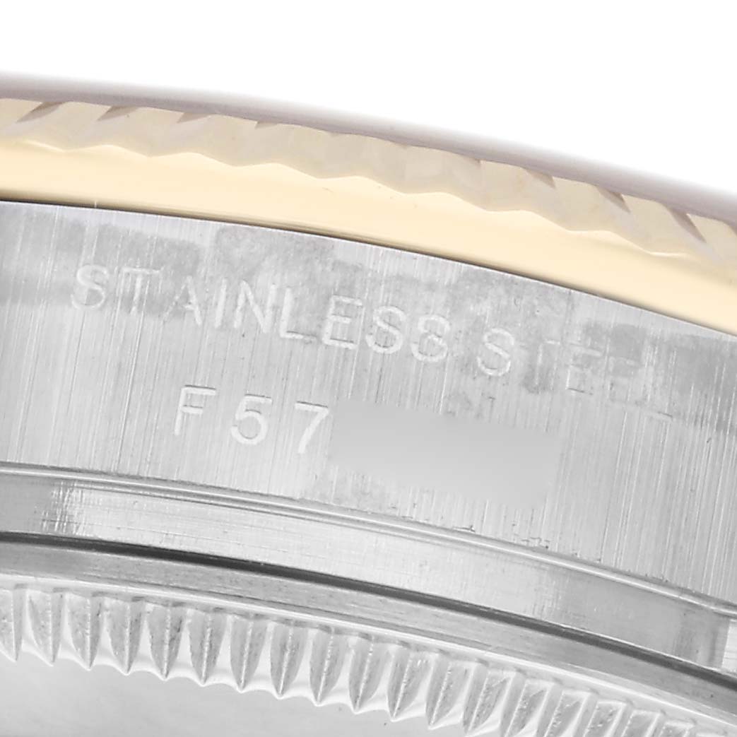 The image shows a close-up of the Rolex Datejust 179173 Women's Steel and Gold (two tone) White Dial 179173 Women's Steel and Gold (two tone) White Dial model case, highlighting the stamping and fluted bezel edge.