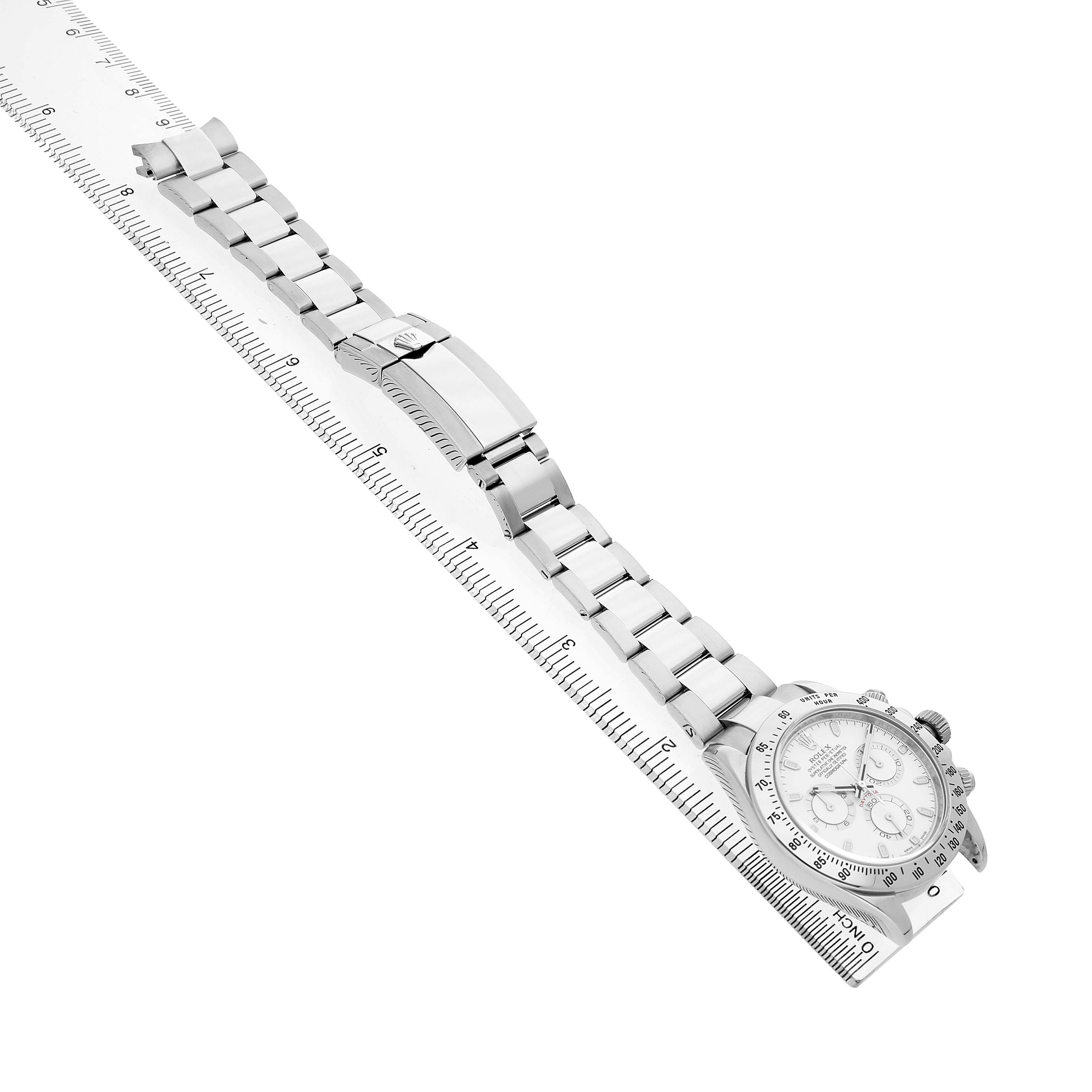 The Rolex Daytona 116520 Men's Stainless Steel White Dial watch is shown at an angle displaying the face, bracelet, and clasp, aligned with a ruler for scale.
