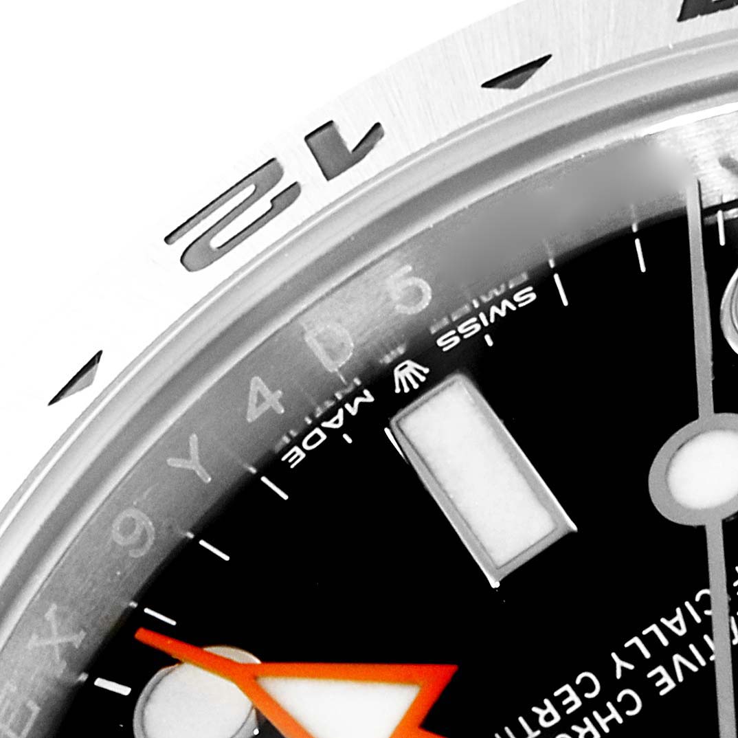 The image shows a close-up of the Rolex Explorer 226570 Men
s Stainless Steel Black Dial 226570 Men
s Stainless Steel Black Dial watch dial and bezel, focusing on the hour markers and parts of the minute hand.