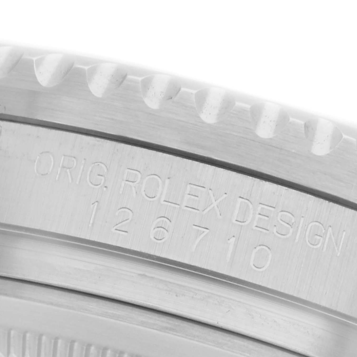 The image shows a close-up of the case side of a Rolex GMT-Master 126710GRNR Men
s Stainless Steel Black Dial 126710GRNR Men
s Stainless Steel Black Dial, displaying engravings on the metal.