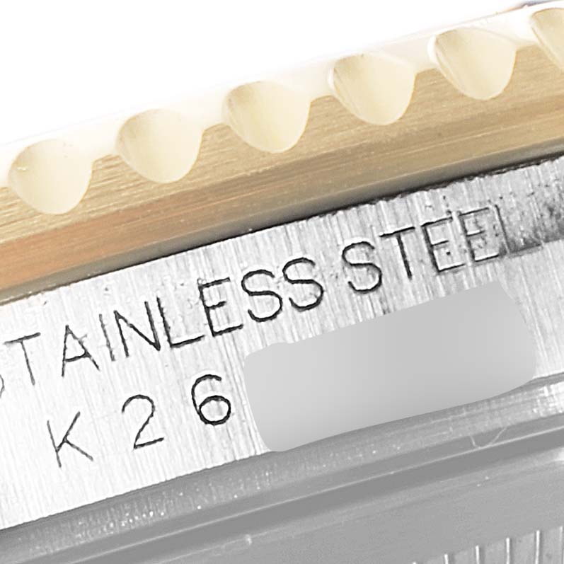 The image shows a close-up of the side of a Rolex GMT-Master 16713 Men's Steel and Gold (two tone) Black Dial 16713 Men's Steel and Gold (two tone) Black Dial watch with engravings and the edge of the bezel visible.