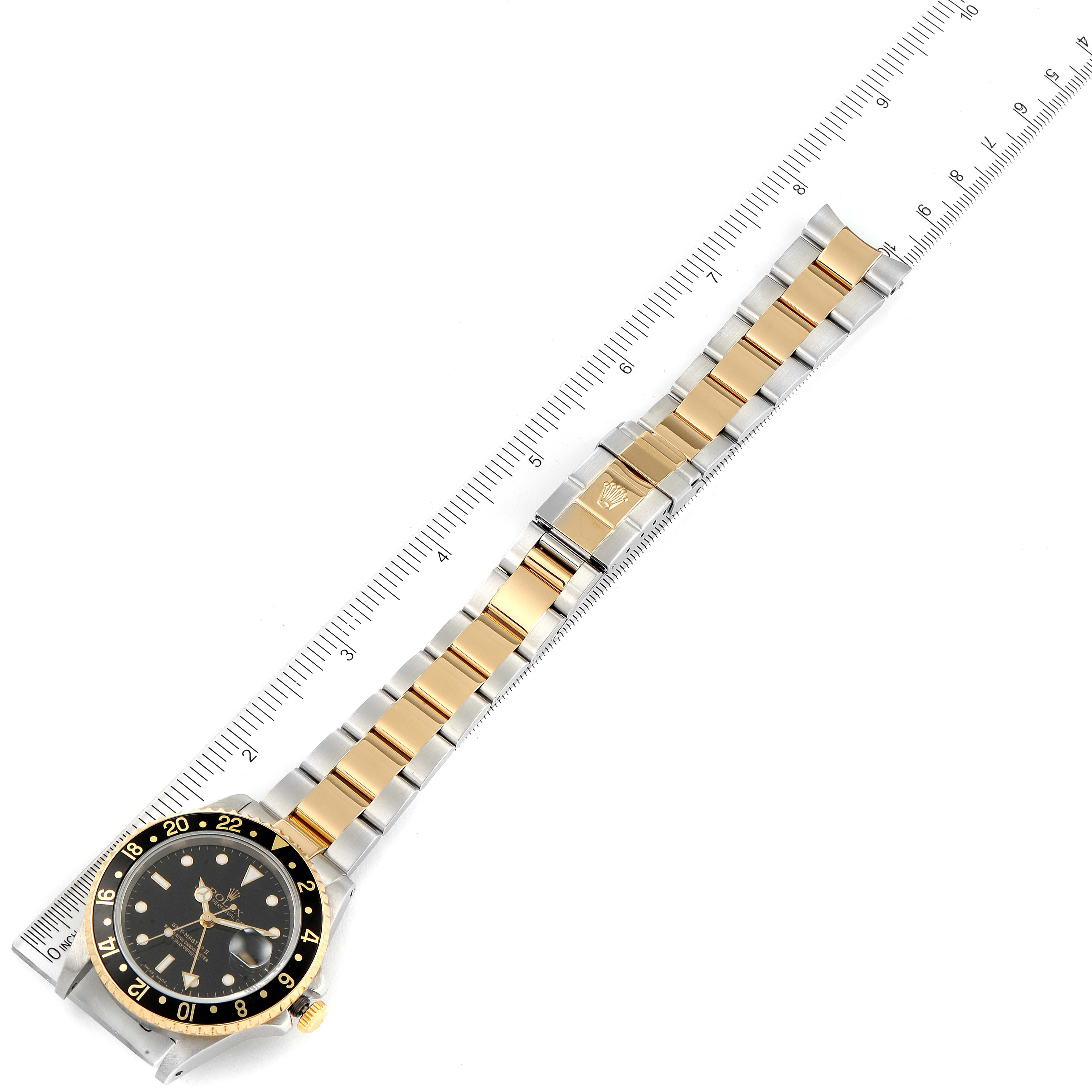 The image shows an overhead view of a Rolex GMT-Master 16713 Men's Steel and Gold (two tone) Black Dial 16713 Men's Steel and Gold (two tone) Black Dial watch, highlighting its black dial, bezel, and two-tone metal bracelet.