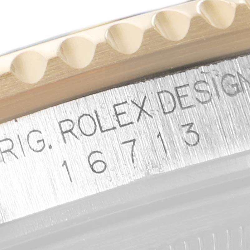 The image shows a close-up of the Rolex GMT-Master 16713 Men's Steel and Gold (two tone) Black Dial 16713 Men's Steel and Gold (two tone) Black Dial's model number 16713 engraved on the side of the watch case.