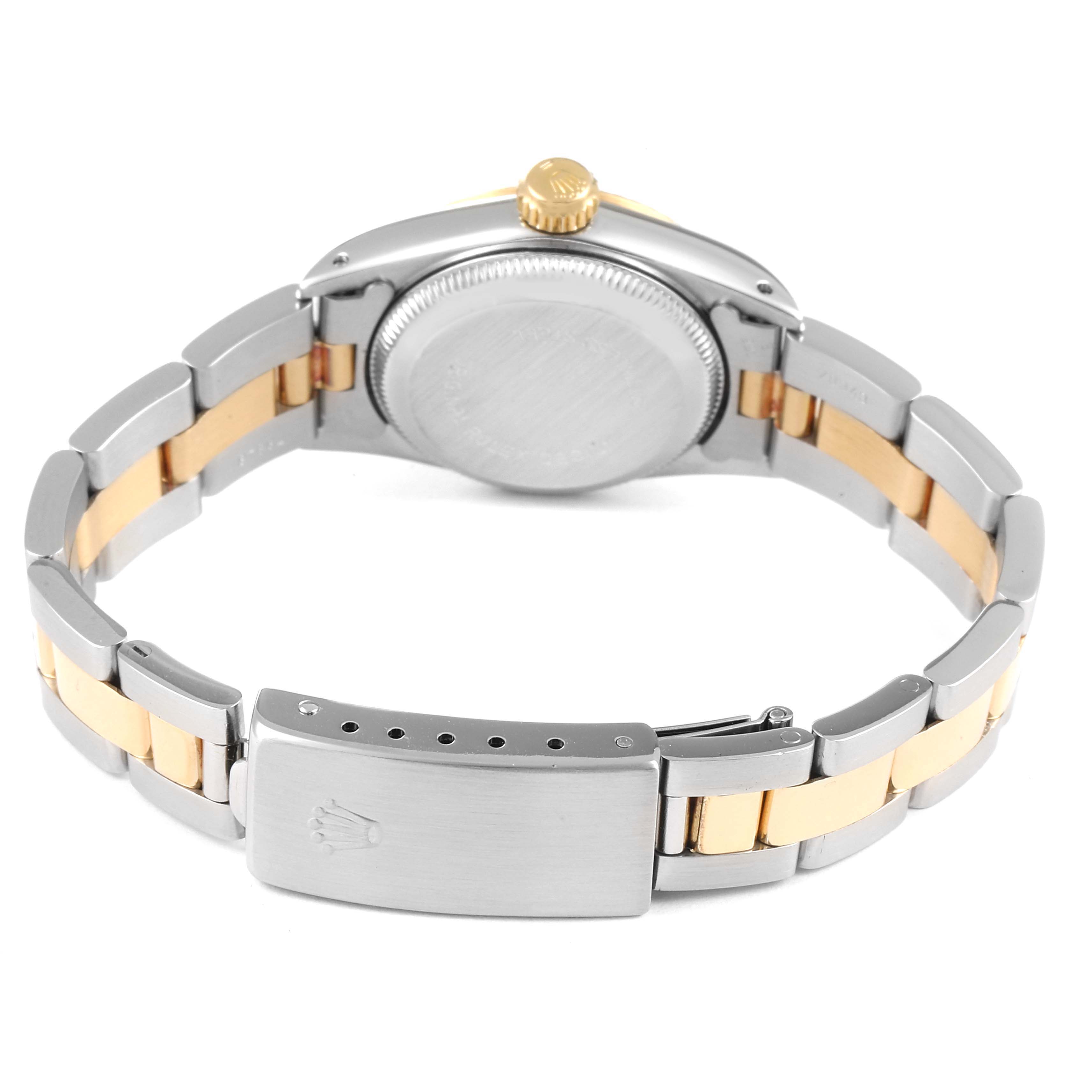 This image shows the back and clasp of a Rolex Oyster Perpetual 67193 Women
s Steel and Gold (two tone) Champagne Dial 67193 Women
s Steel and Gold (two tone) Champagne Dial watch, highlighting its two-tone metal band and crown.