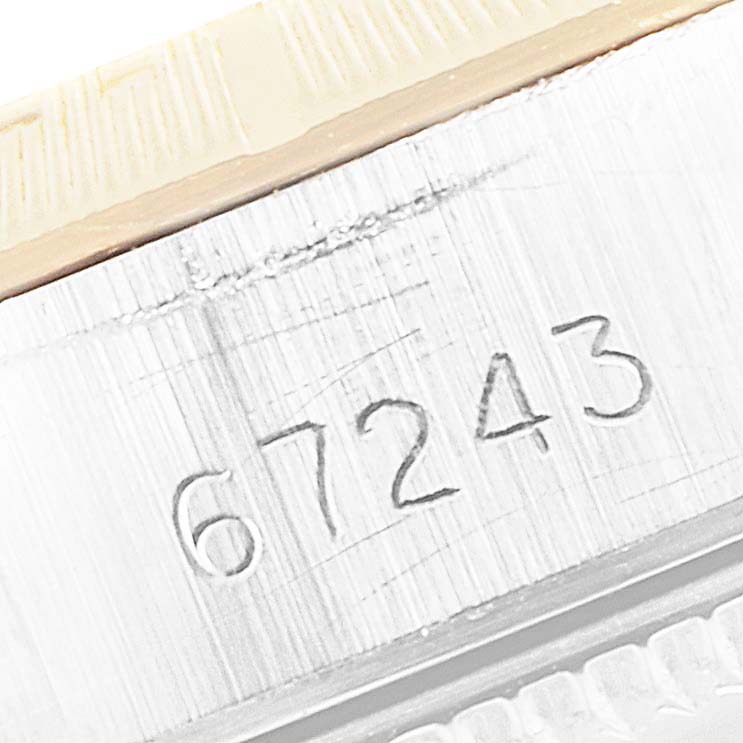 This close-up image shows part of the case and serial number "67243" of a Rolex Oyster Perpetual 67243 Women
s Steel and Gold (two tone) Champagne Dial 67243 Women
s Steel and Gold (two tone) Champagne Dial watch.