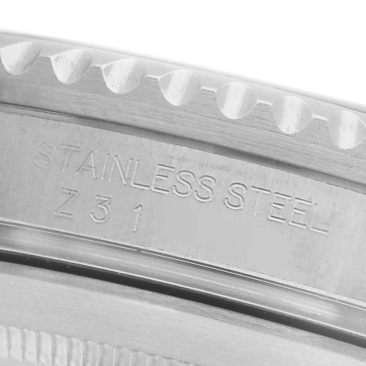 The image shows a close-up of the edge of a Rolex Submariner 16610 Men
s Stainless Steel Black Dial 16610 Men
s Stainless Steel Black Dial, highlighting the stainless steel bezel and engravings.