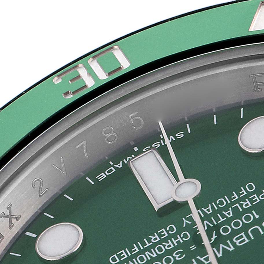 The image shows a close-up of the Rolex Submariner 116610LV Men
s Stainless Steel Green Dial 116610LV Men
s Stainless Steel Green Dial
s green bezel and part of its dial, focusing on the hour markers and hands.