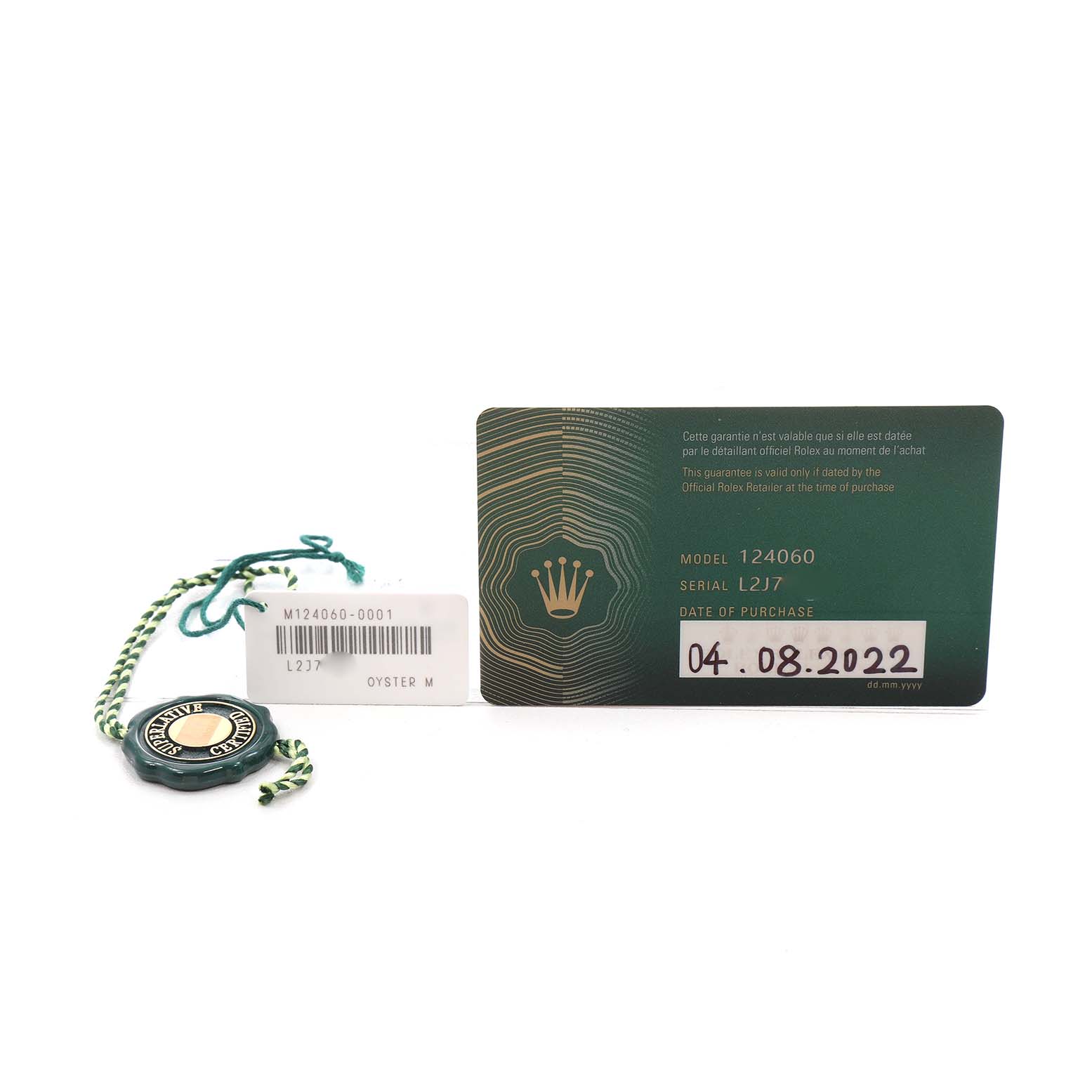 The image shows a Rolex Submariner M124060-0001 Men's Stainless Steel Black Dial model's warranty card and tag from a straight-on angle.