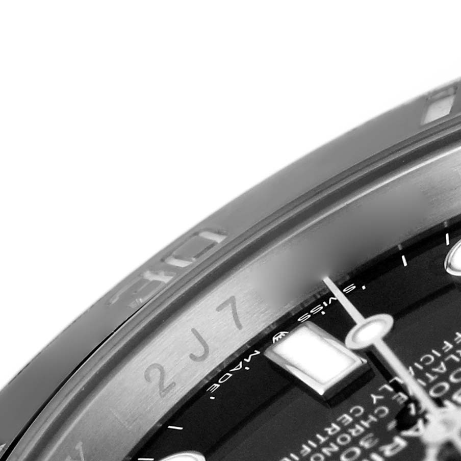 The image shows a close-up of the bezel and part of the dial of a Rolex Submariner M124060-0001 Men's Stainless Steel Black Dial watch, highlighting the edge markings and a portion of the indices.