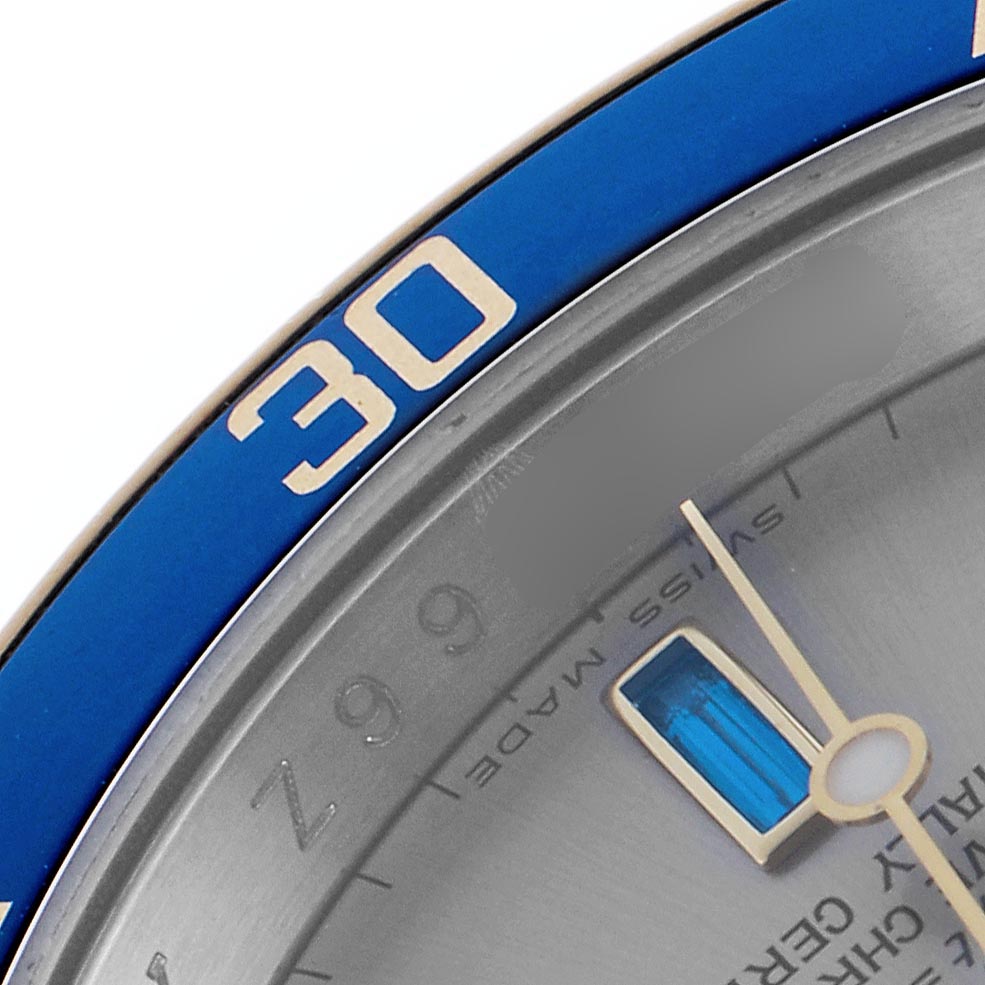 The image shows a close-up of a Rolex Submariner 16613 Men
s Steel and Gold (two tone) Silver Dial 16613 Men
s Steel and Gold (two tone) Silver Dial, highlighting its blue bezel with the "30" marker and part of the dial and hand.