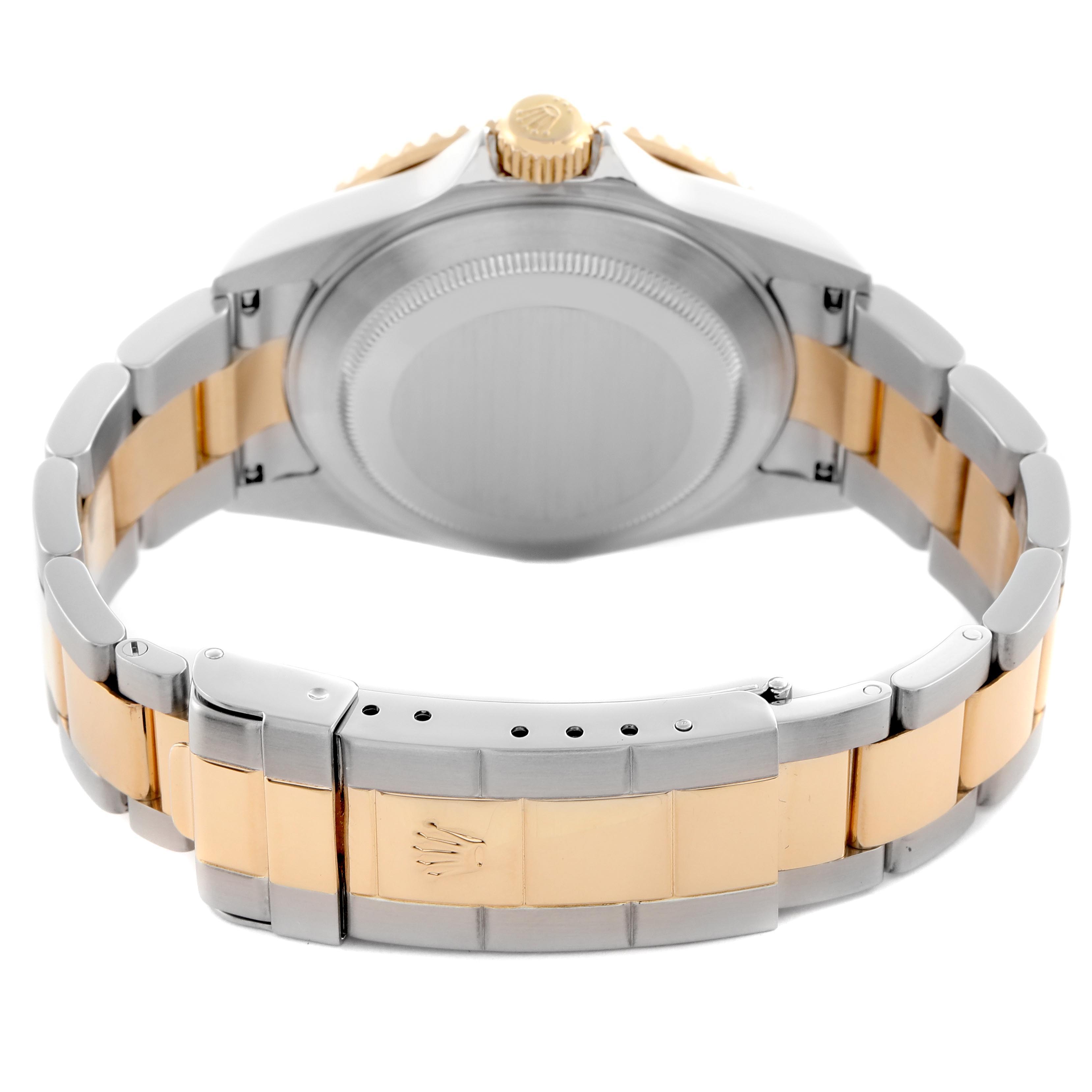 The image shows a rear view of a Rolex Submariner 16613 Men
s Steel and Gold (two tone) Silver Dial 16613 Men
s Steel and Gold (two tone) Silver Dial, highlighting the case back, crown, and bracelet
s two-tone links.