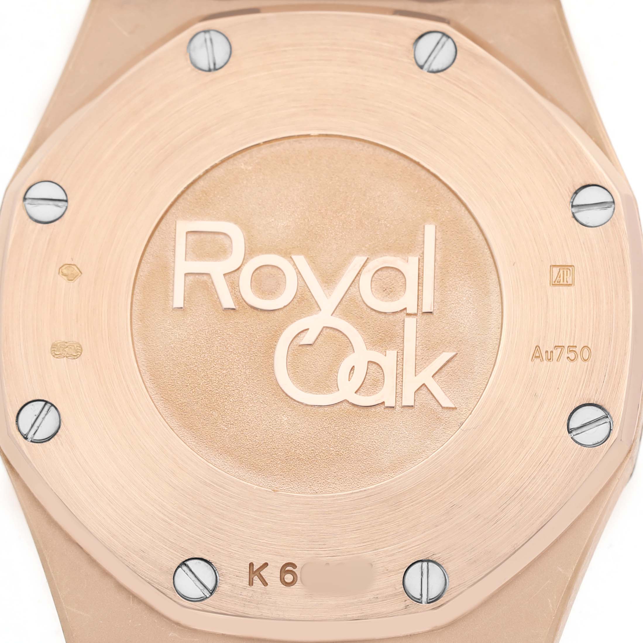 The image shows the case back of an Audemars Piguet Royal Oak 67651OR.ZZ.1261OR.02 Women's Rose Gold Blue Dial watch, highlighting the logo and screws.