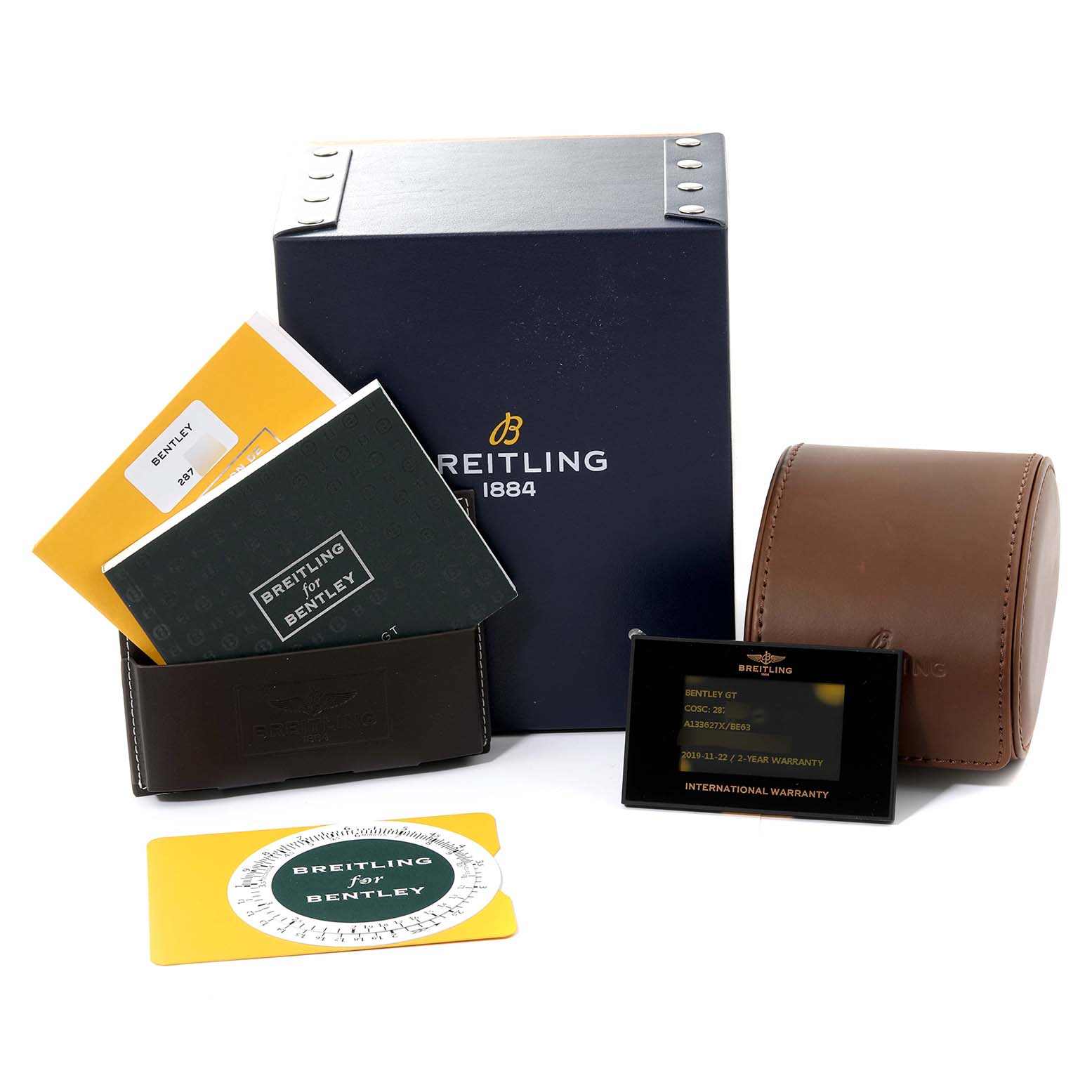 The image shows a Breitling for Bentley watch box, manuals, warranty card, and a brown leather case.