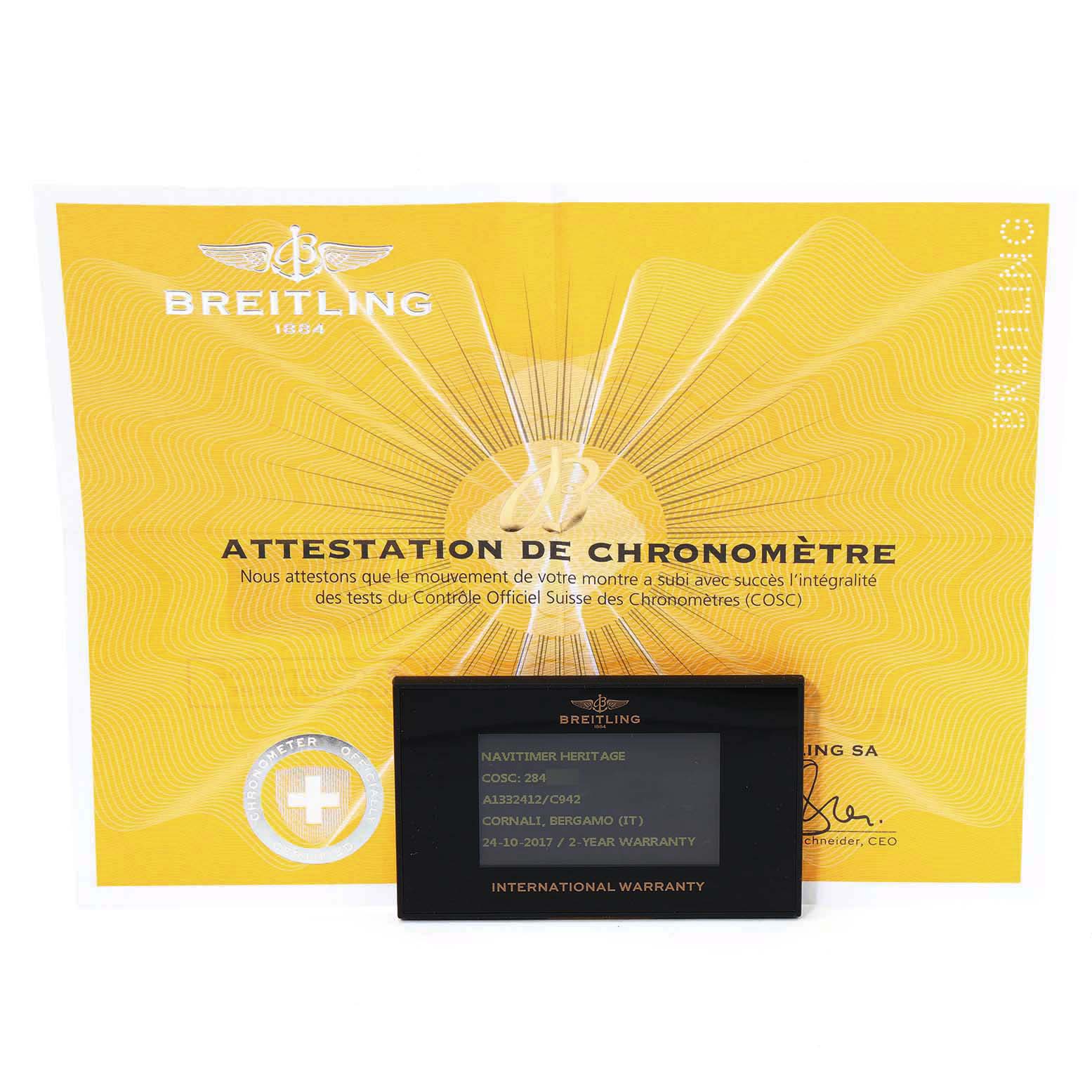 The image shows a Breitling Navitimer A13324 Men
s Stainless Steel Blue Dial A13324 Men
s Stainless Steel Blue Dial certificate and an international warranty card placed in front of it.