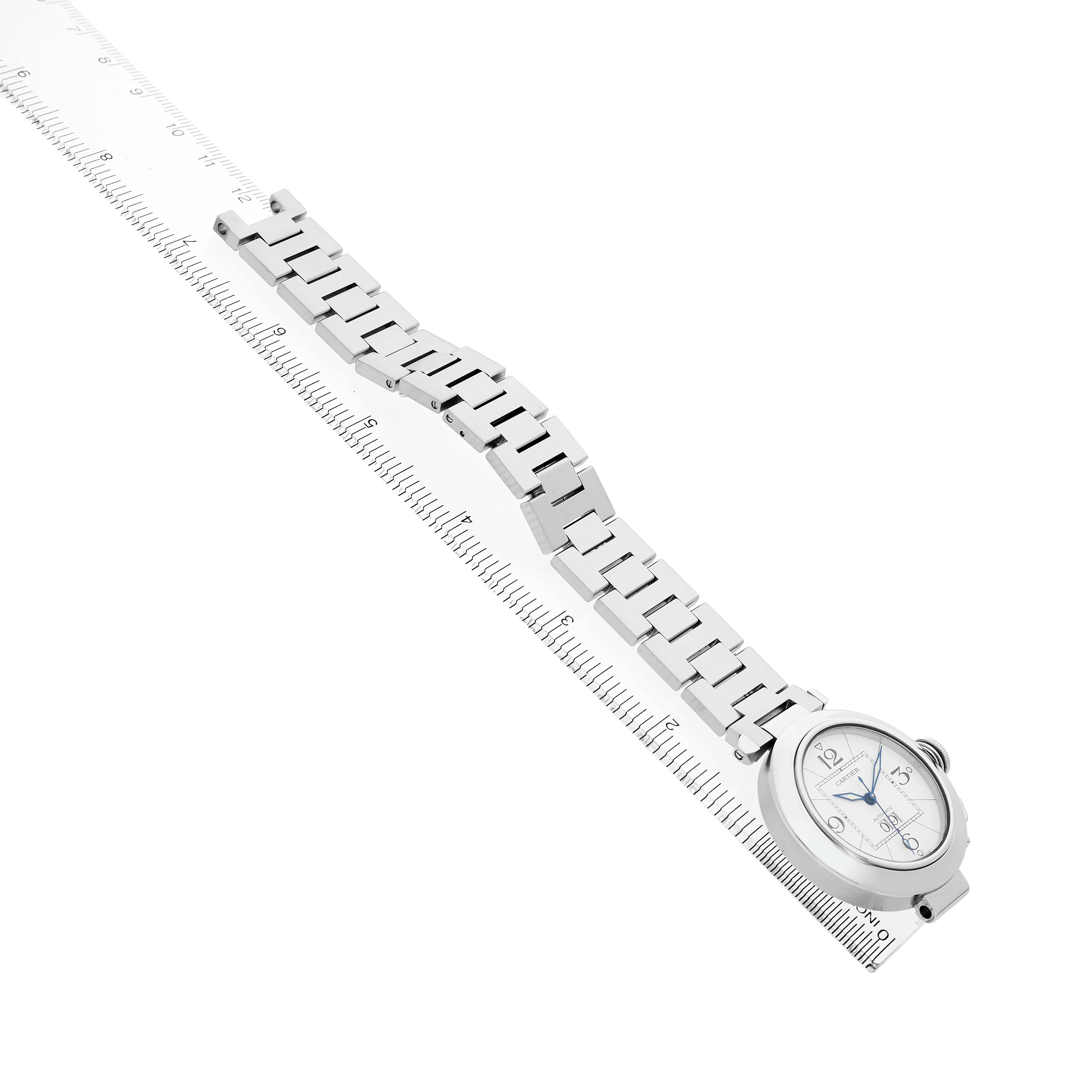 The image shows a Cartier Pasha W31055M7 Men's Stainless Steel White Dial watch laid out flat, highlighting the watch face and linked bracelet lengthwise with a ruler alongside.