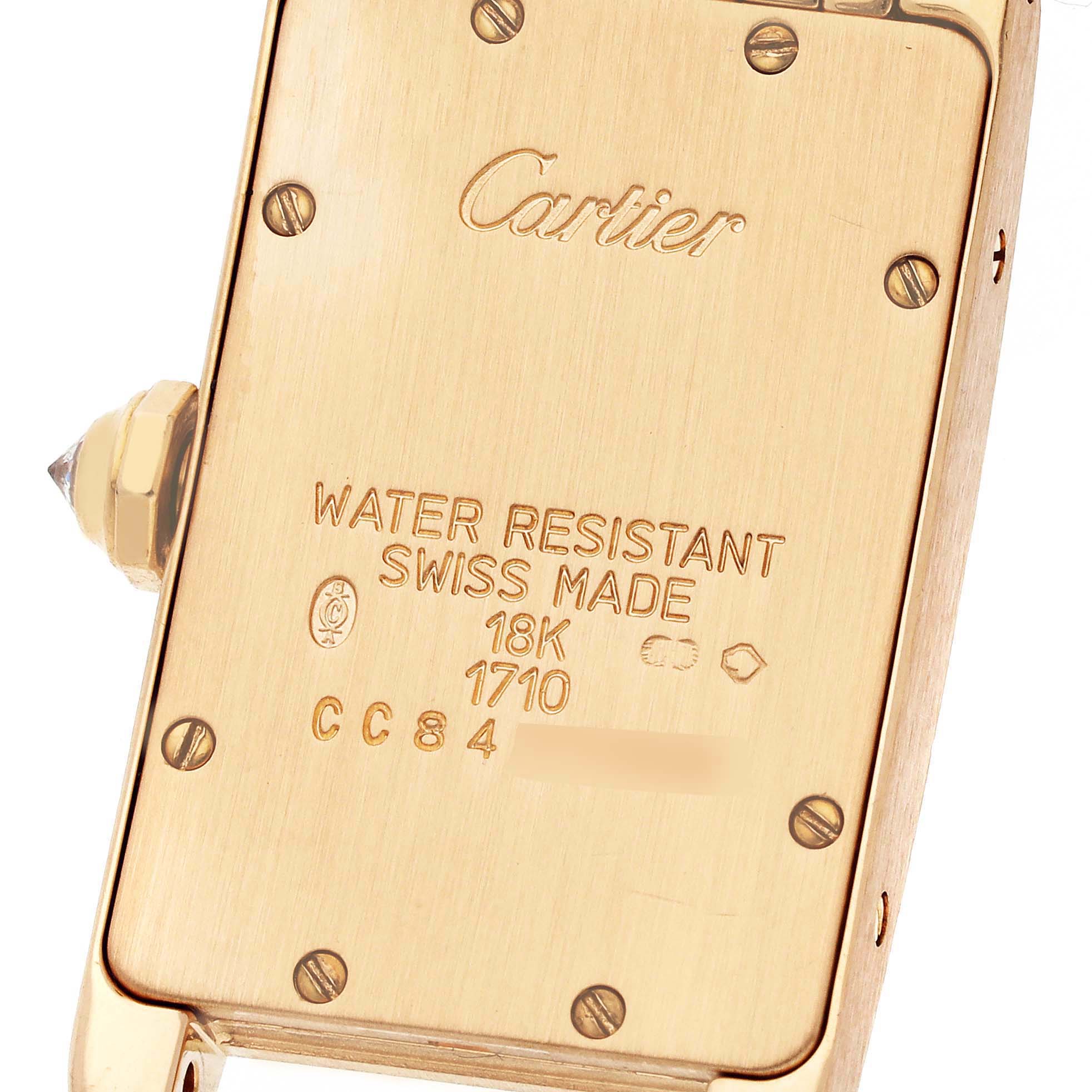 The image shows the back case of a Cartier Tank Americaine WB7012K2 Women's Yellow Gold Silver Dial WB7012K2 Women's Yellow Gold Silver Dial watch, highlighting the engravings and markings.