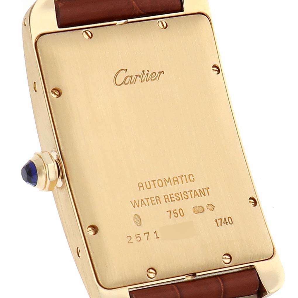 This image shows the back casing and crown of the Cartier Tank Américaine watch, highlighting its automatic movement and inscriptions.