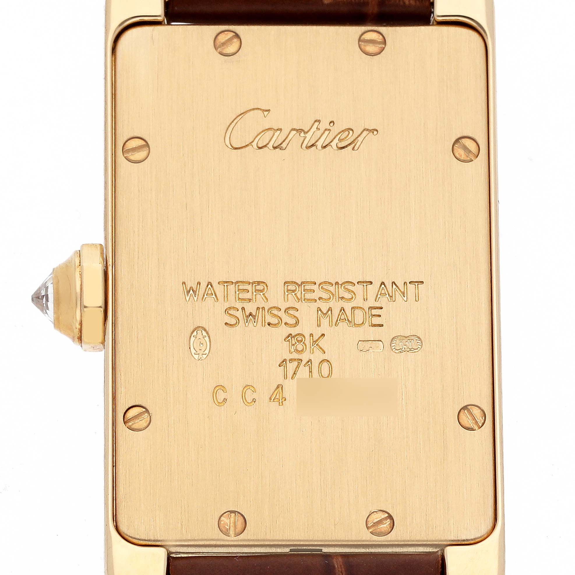 The image shows the back case of a Cartier Tank Americaine WB701251 Women's Yellow Gold Silver Dial WB701251 Women's Yellow Gold Silver Dial watch, highlighting its engravings and the crown with a jewel.