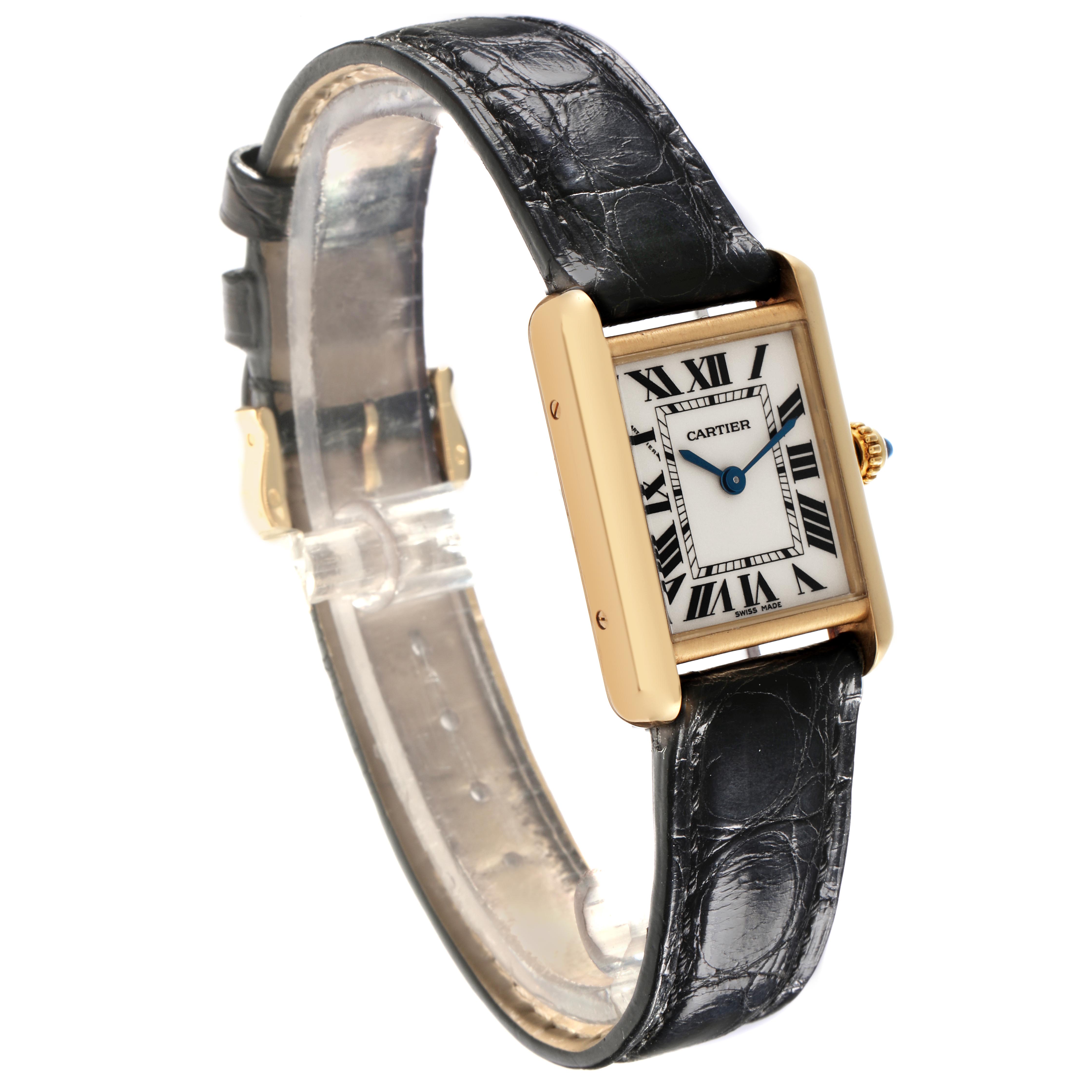The image shows a Cartier Tank Louis W1529856 Women
s Yellow Gold Silver Dial W1529856 Women
s Yellow Gold Silver Dial watch at an angle highlighting its face, leather strap, and gold case with Roman numerals.