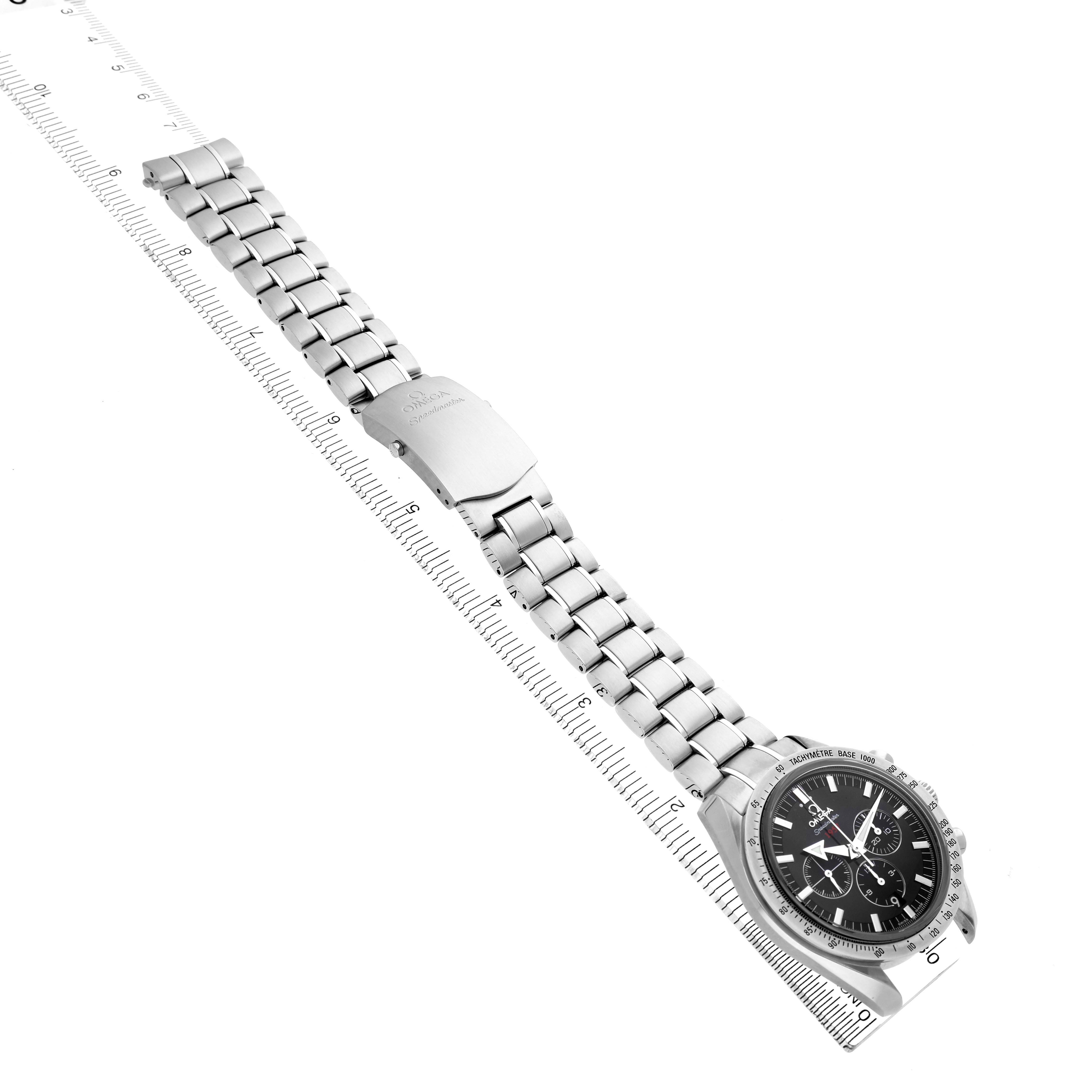 The Omega Speedmaster 321.10.42.50.01.001 Men's Stainless Steel Black Dial watch is shown from an angled overhead view, displaying the face and full metal bracelet along a ruler.