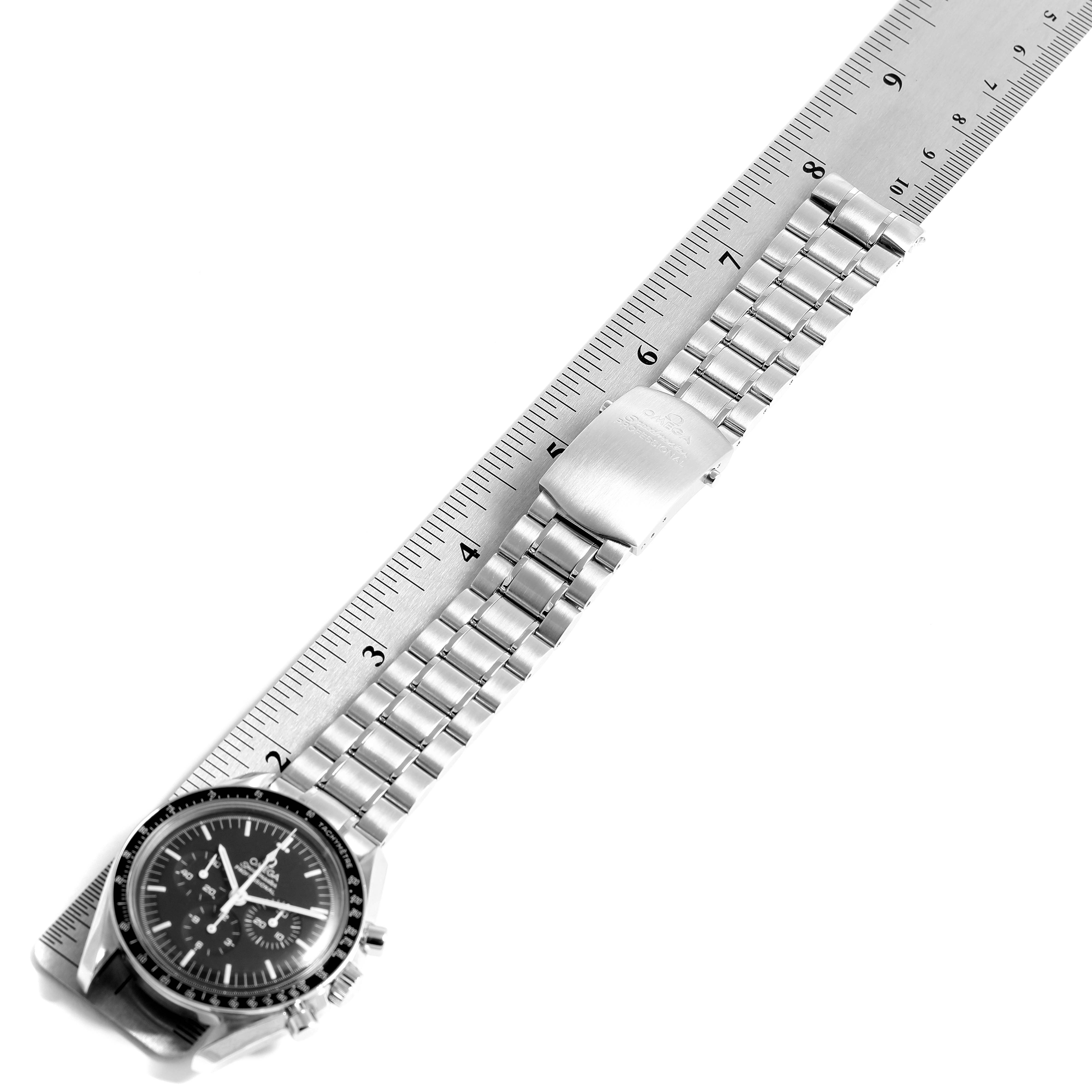 The Omega Speedmaster 3570.50.00 Men
s Stainless Steel Black Dial 3570.50.00 Men
s Stainless Steel Black Dial watch is shown from an oblique angle, highlighting the full bracelet and clasp, beside a ruler.