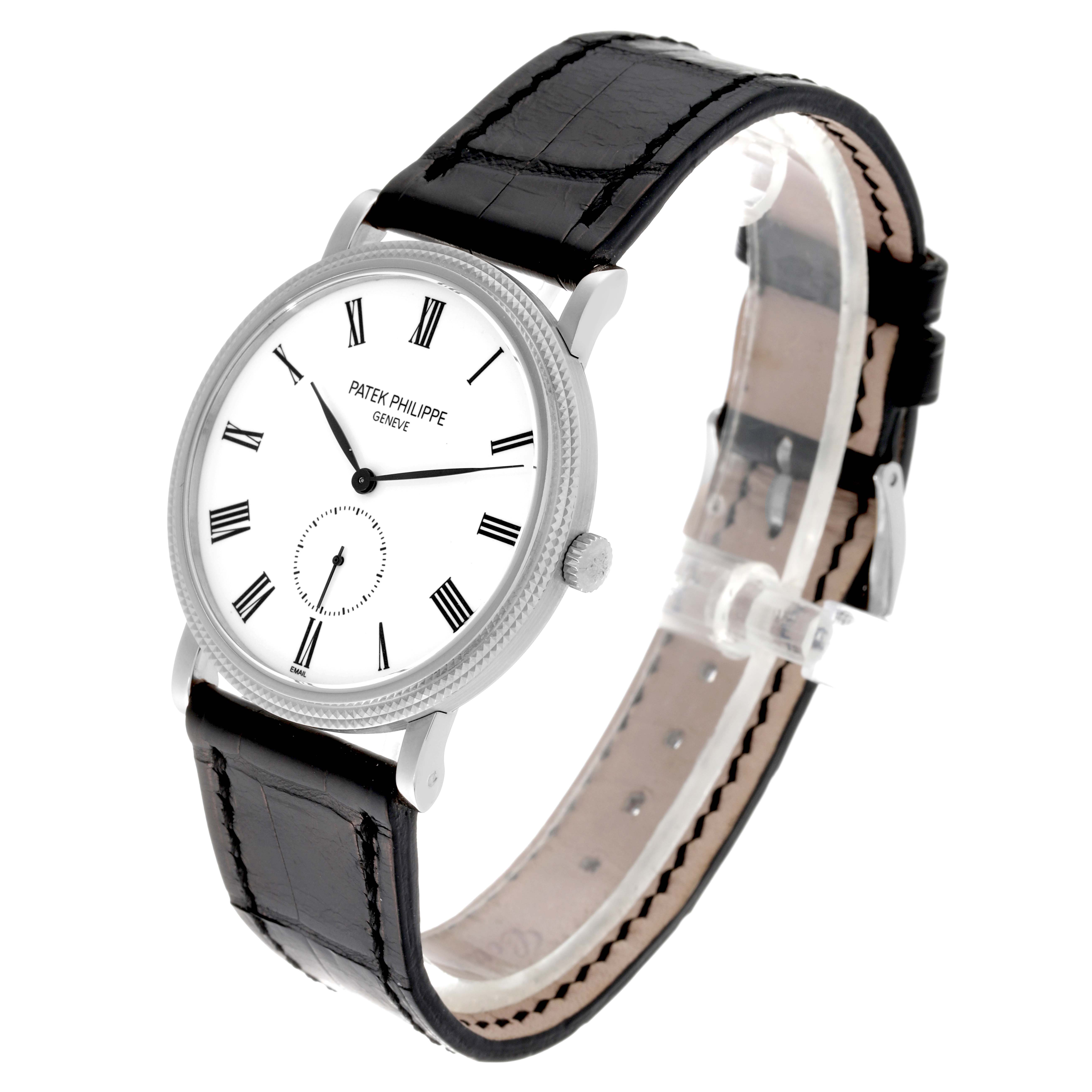 The image shows a Patek Philippe Calatrava 5116G Men
s White Gold White Dial 5116G Men
s White Gold White Dial model watch at a three-quarter angle, highlighting its face, bezel, and black leather strap.