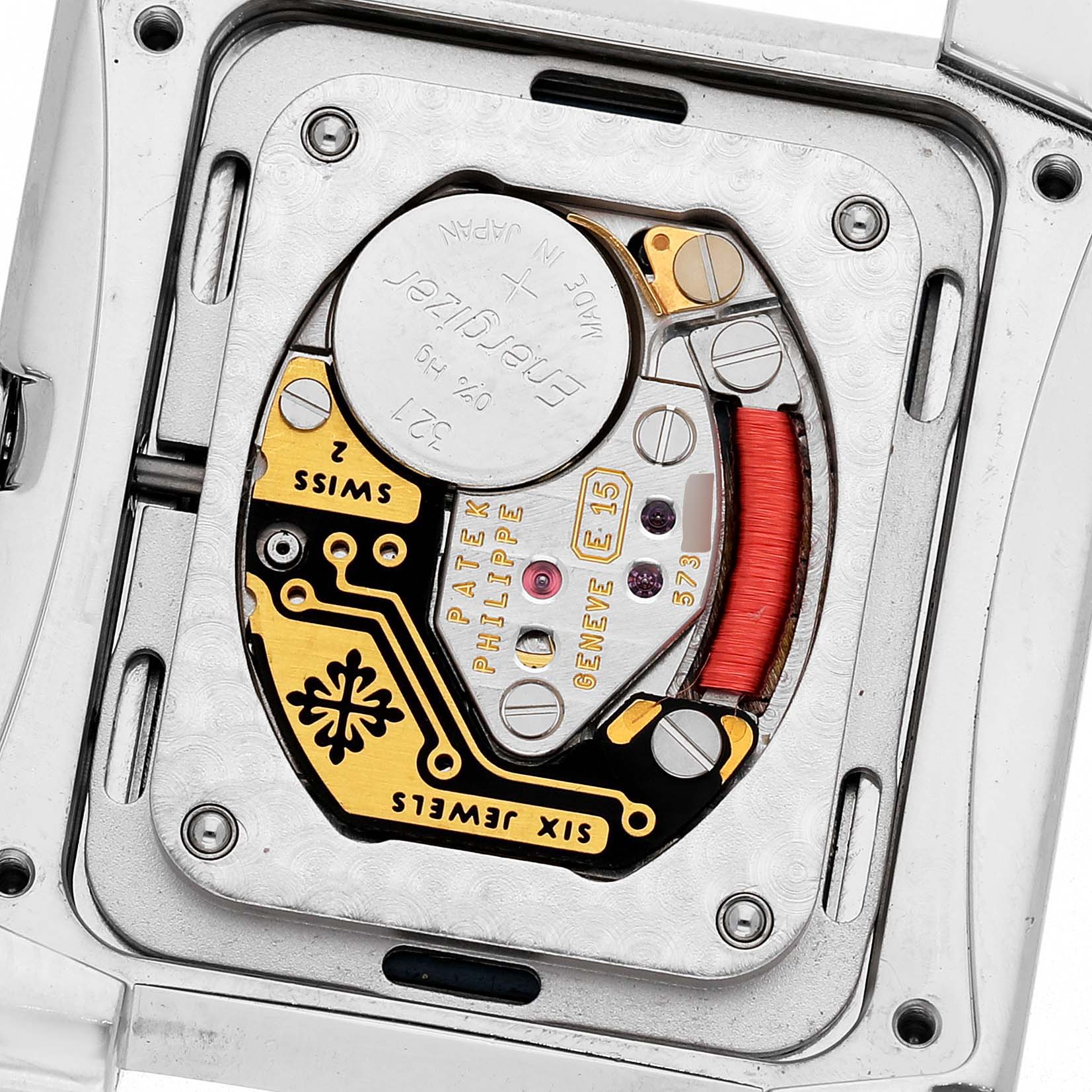 The image shows the back view of a Patek Philippe Twenty-4 4910/10A-012 Women's Stainless Steel Blue Dial watch, highlighting its intricate movement and battery.
