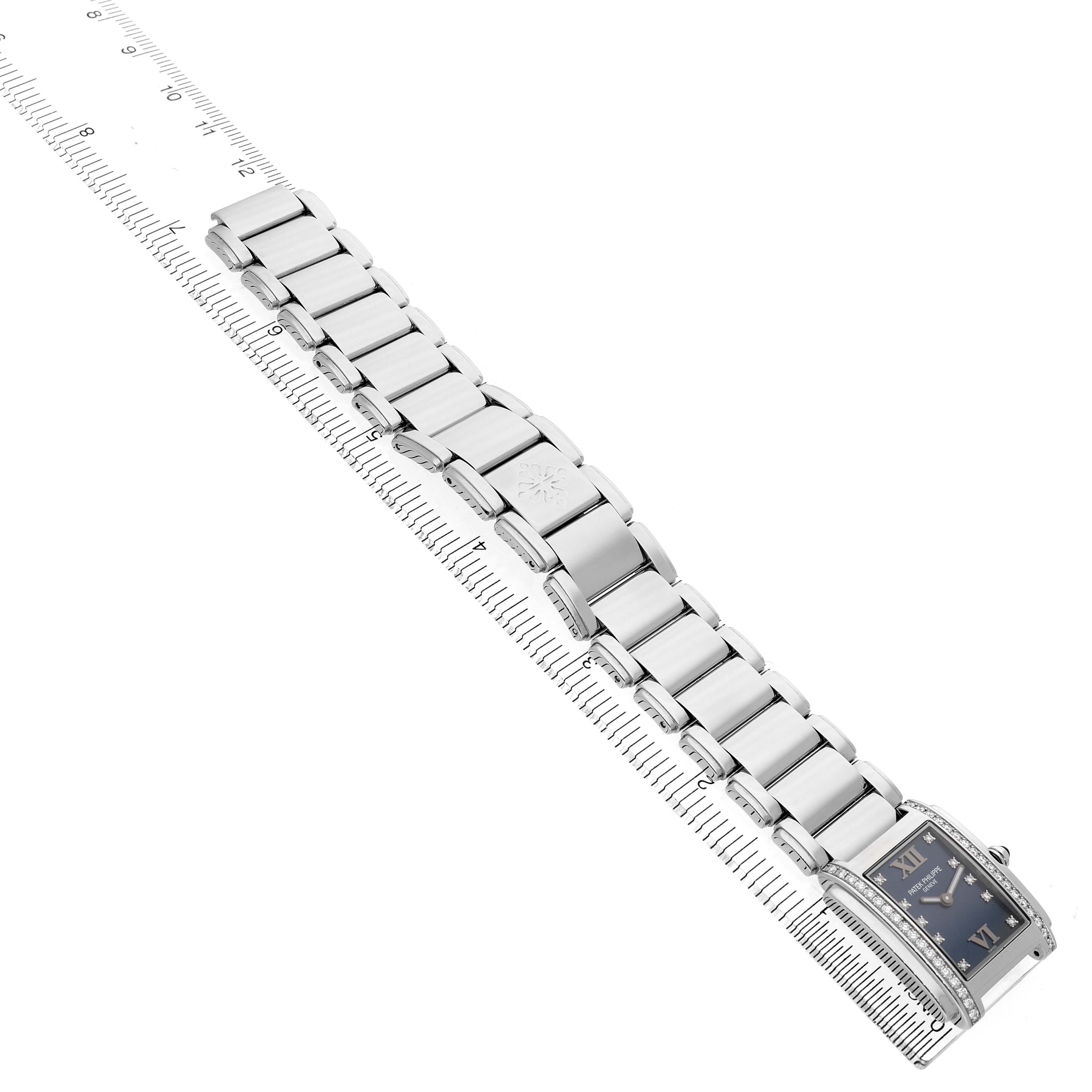 The Patek Philippe Twenty-4 4910/10A-012 Women's Stainless Steel Blue Dial watch is shown from an angled top view, highlighting the bracelet and face with a ruler for scale.
