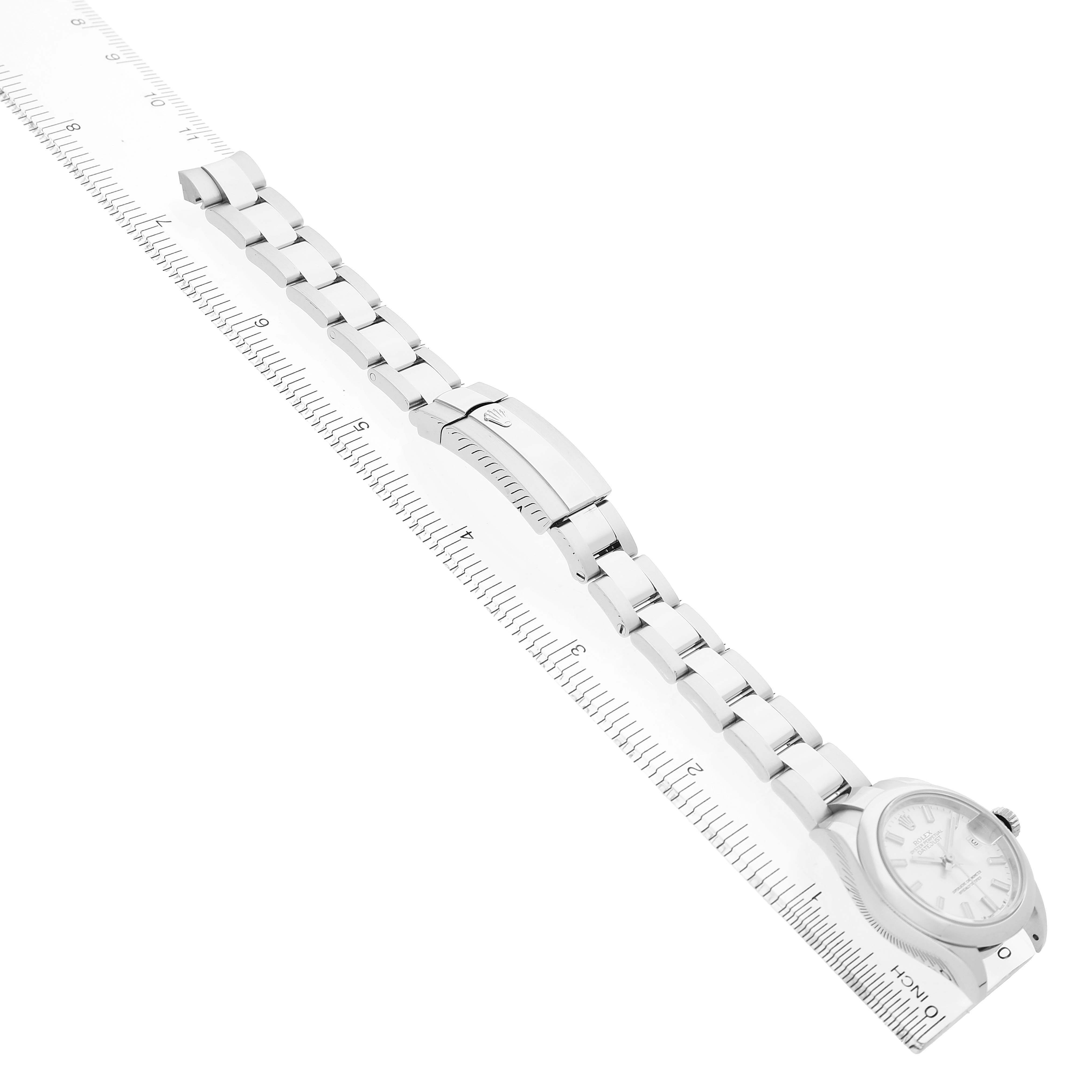 The image shows a Rolex Datejust 279160 Women's Stainless Steel Silver Dial watch with its full bracelet laid out diagonally, accompanied by a ruler for size reference.