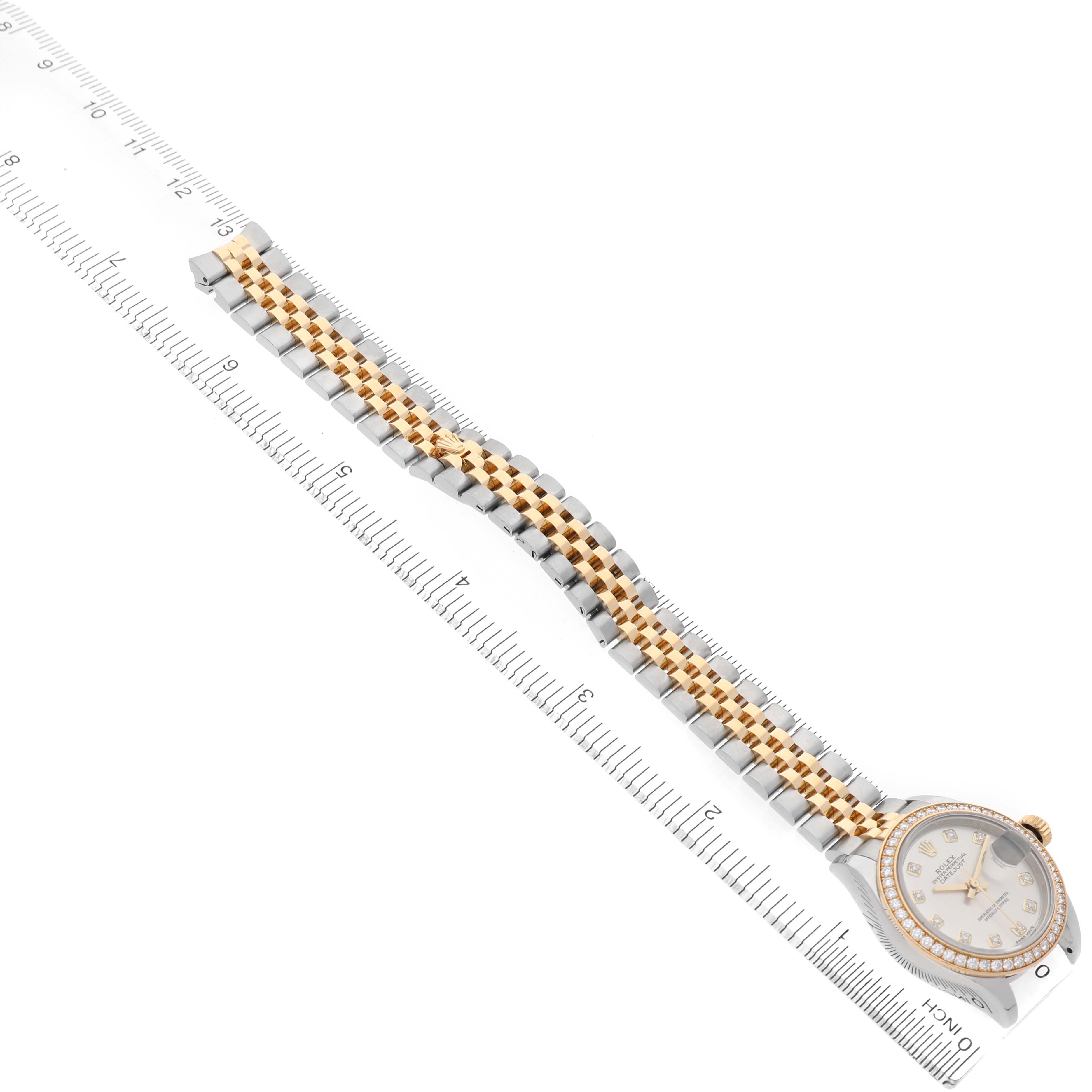 The image shows a Rolex Datejust 279383 Women's Stainless Steel Silver Dial watch angled diagonally, highlighting its face and a two-tone bracelet next to a ruler.