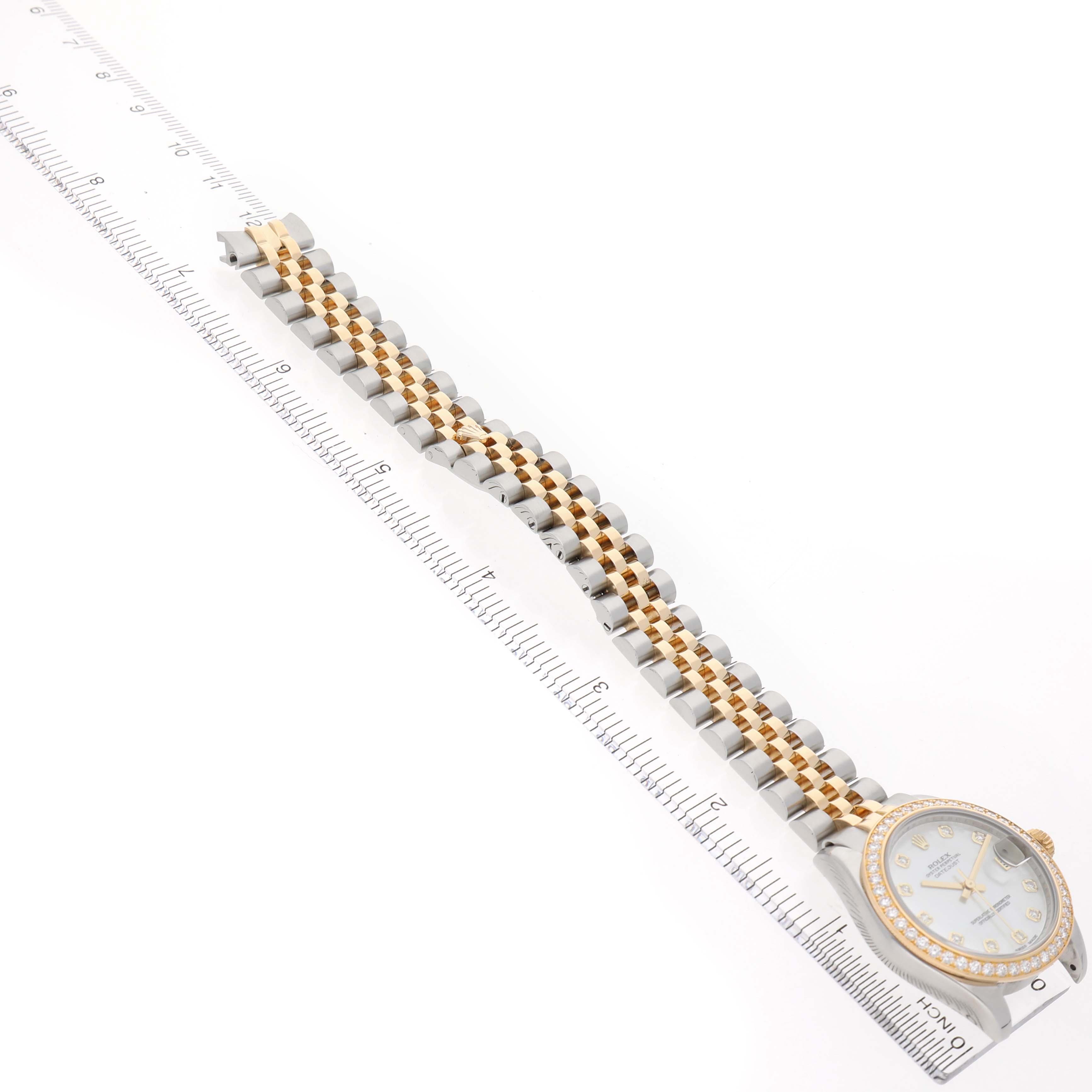 The Rolex Datejust Midsize 31 is shown diagonally with the bracelet and dial partially visible.