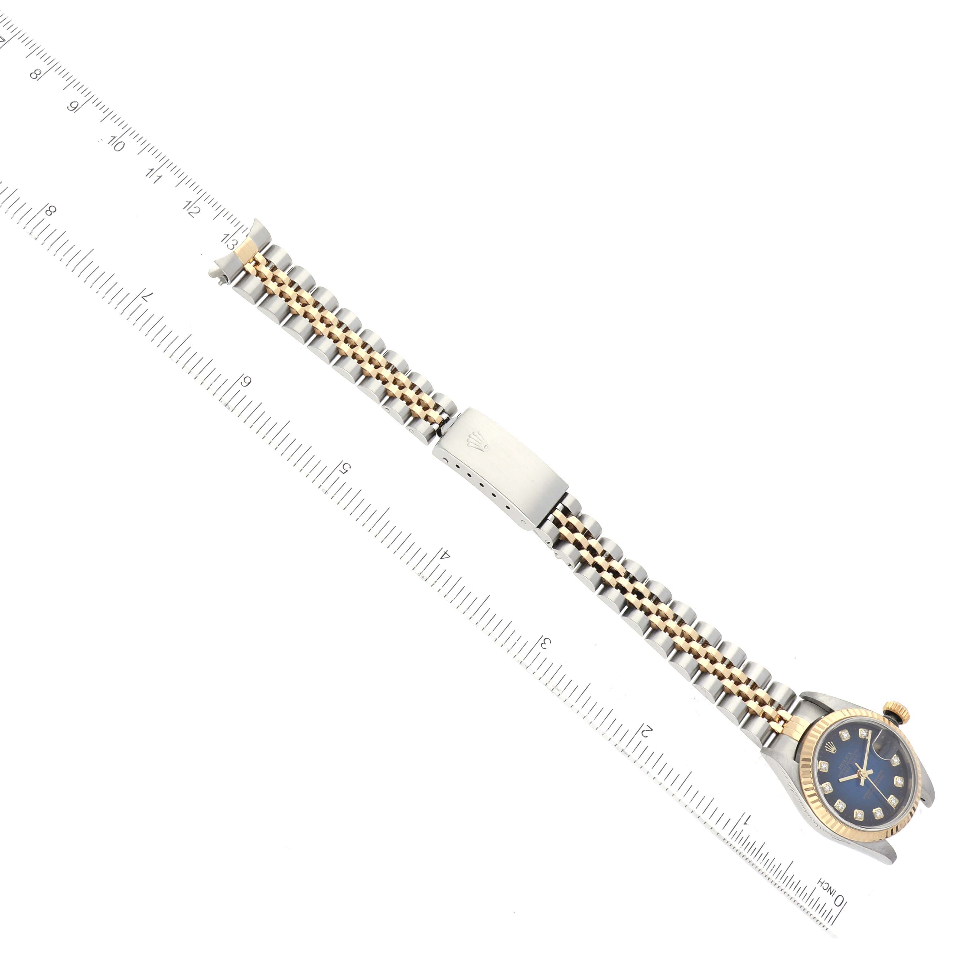 The image shows a Rolex Datejust 79173 Women's Steel and Gold (two tone) Blue Dial 79173 Women's Steel and Gold (two tone) Blue Dial watch laid flat with its bracelet spread straight, next to a ruler for scale.