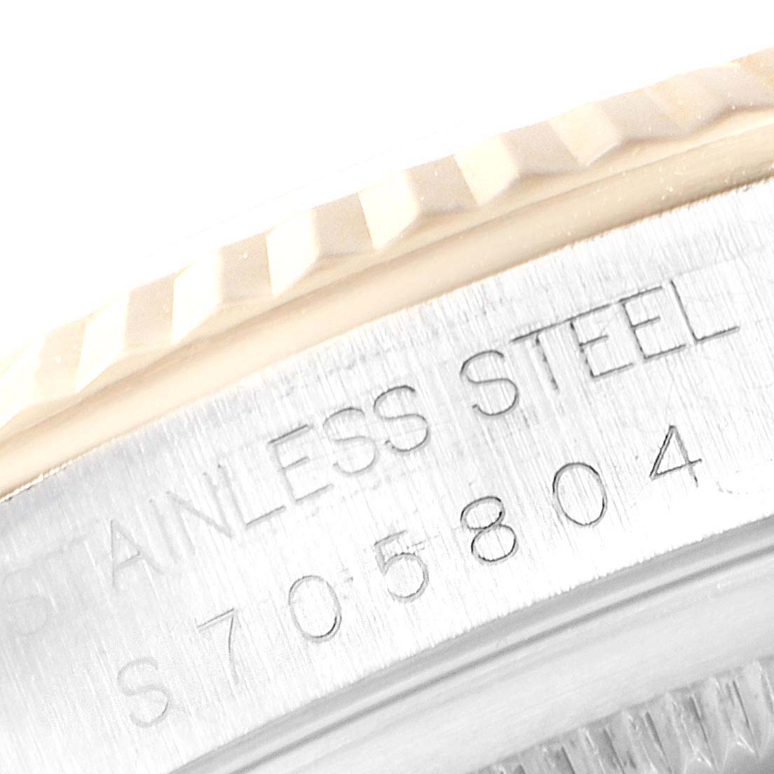 This image shows a close-up of the serial number and "STAINLESS STEEL" engraving on the casing of a Rolex Datejust 16233 Men
s Steel and Gold (two tone) Champagne Dial 16233 Men
s Steel and Gold (two tone) Champagne Dial watch.