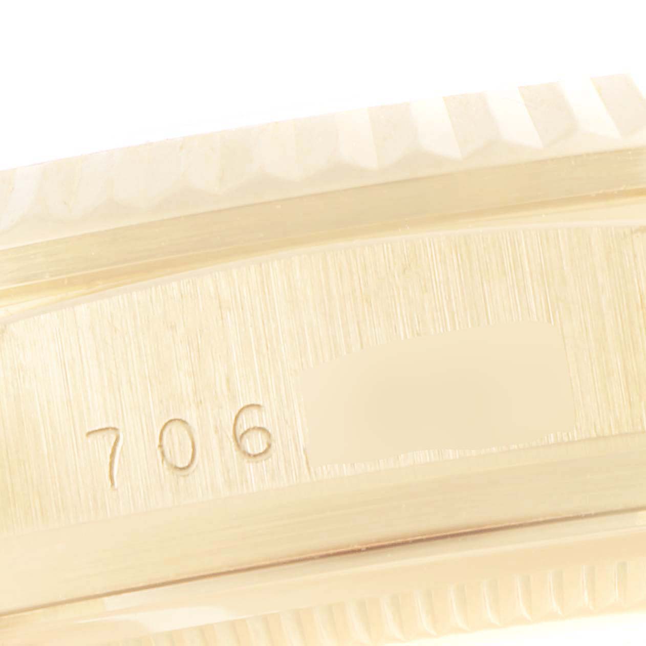 The image shows a close-up of the side of a Rolex Datejust 16018 Men's Yellow Gold Black Dial 16018 Men's Yellow Gold Black Dial watch, featuring the serial number engraved on the case.