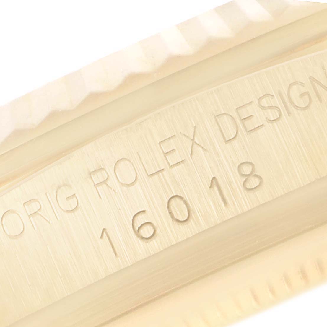 This close-up image shows the model number and "Orig Rolex Design" engraving on the side of a Rolex Datejust 16018 Men's Yellow Gold Black Dial 16018 Men's Yellow Gold Black Dial watch case.