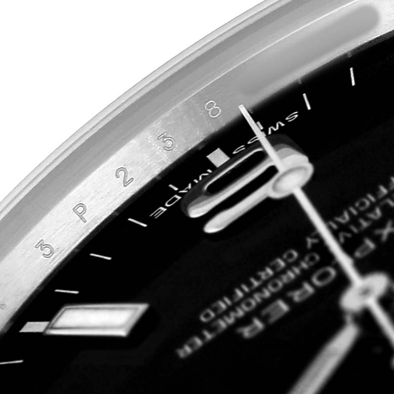 The image shows a close-up of the dial and hands of a Rolex Explorer 214270 Men's Stainless Steel Black Dial watch, focusing on the hour markers and text.