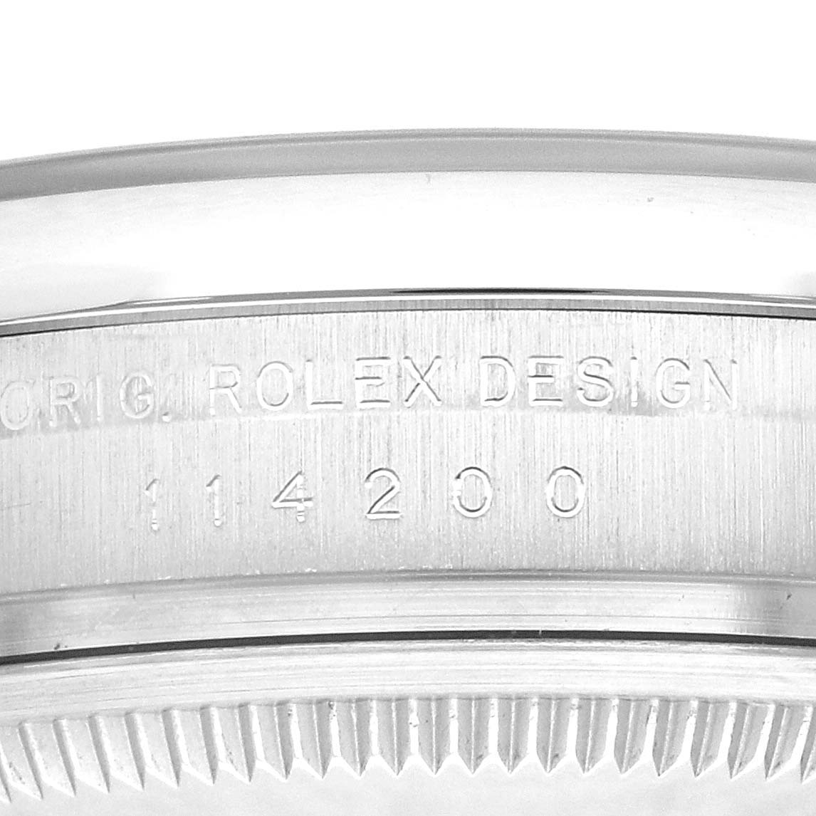 This image shows a close-up of the case side and bezel teeth of a Rolex Oyster Perpetual 114200 Men's Stainless Steel Champagne Dial 114200 Men's Stainless Steel Champagne Dial watch, highlighting the "ROLEX DESIGN" engraving.