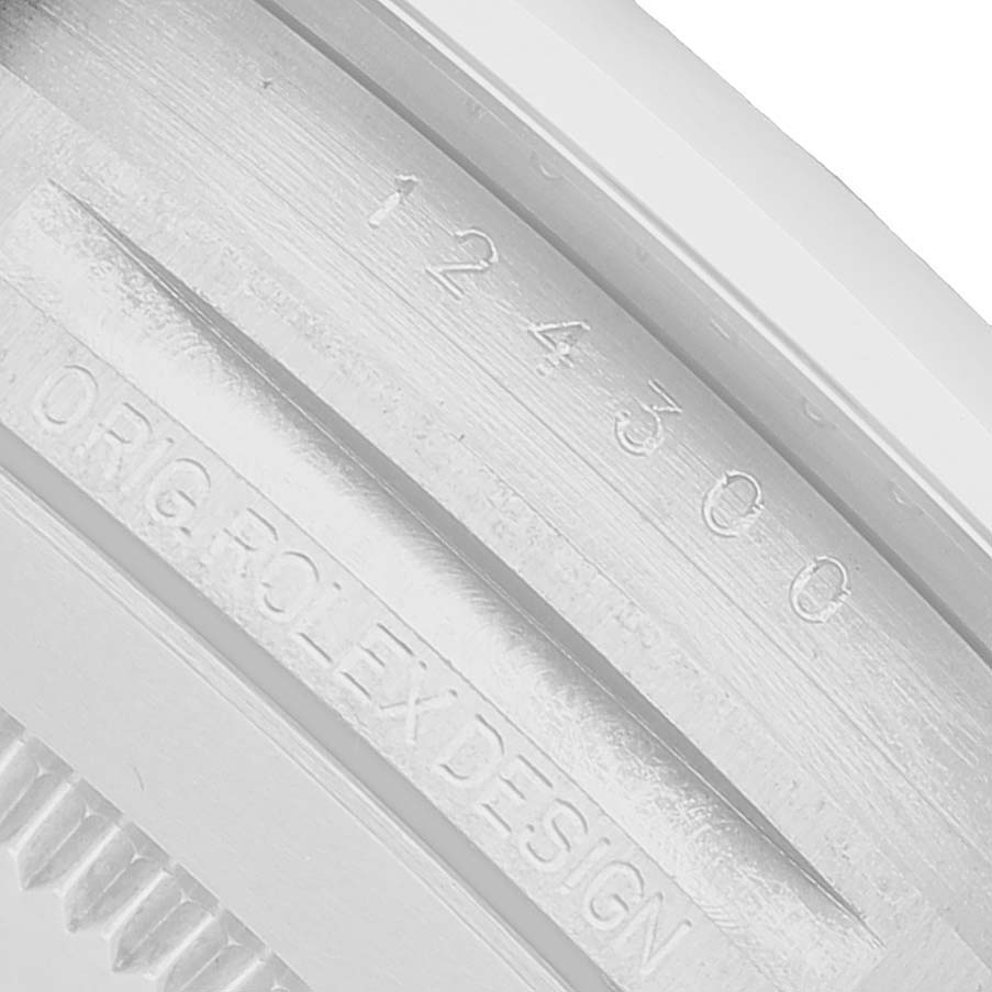 The image shows a close-up of the side of a Rolex Oyster Perpetual 124300-0005 Men's Stainless Steel Green Dial, highlighting the model number and engraving.