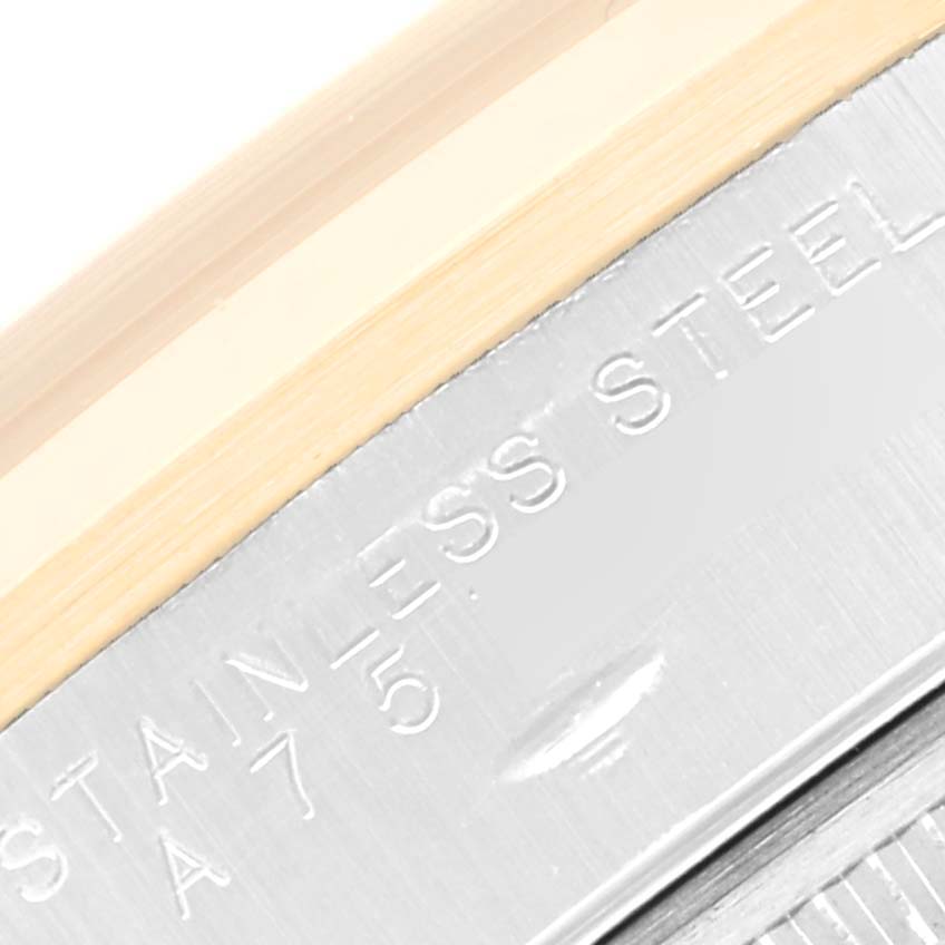 This close-up image shows the edge of the bezel and part of the engraved case back of a Rolex Oyster Perpetual 14203 Men's Steel and Gold (two tone) Grey Dial 14203 Men's Steel and Gold (two tone) Grey Dial watch.