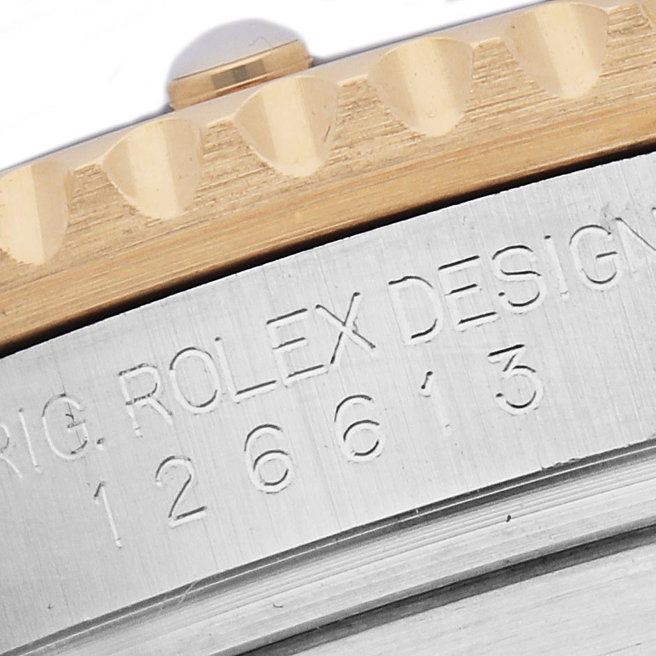The image shows a close-up of the Rolex Submariner 126613 Men
s Steel and Gold (two tone) Blue Dial 126613 Men
s Steel and Gold (two tone) Blue Dial
s engraved side and bezel edge.