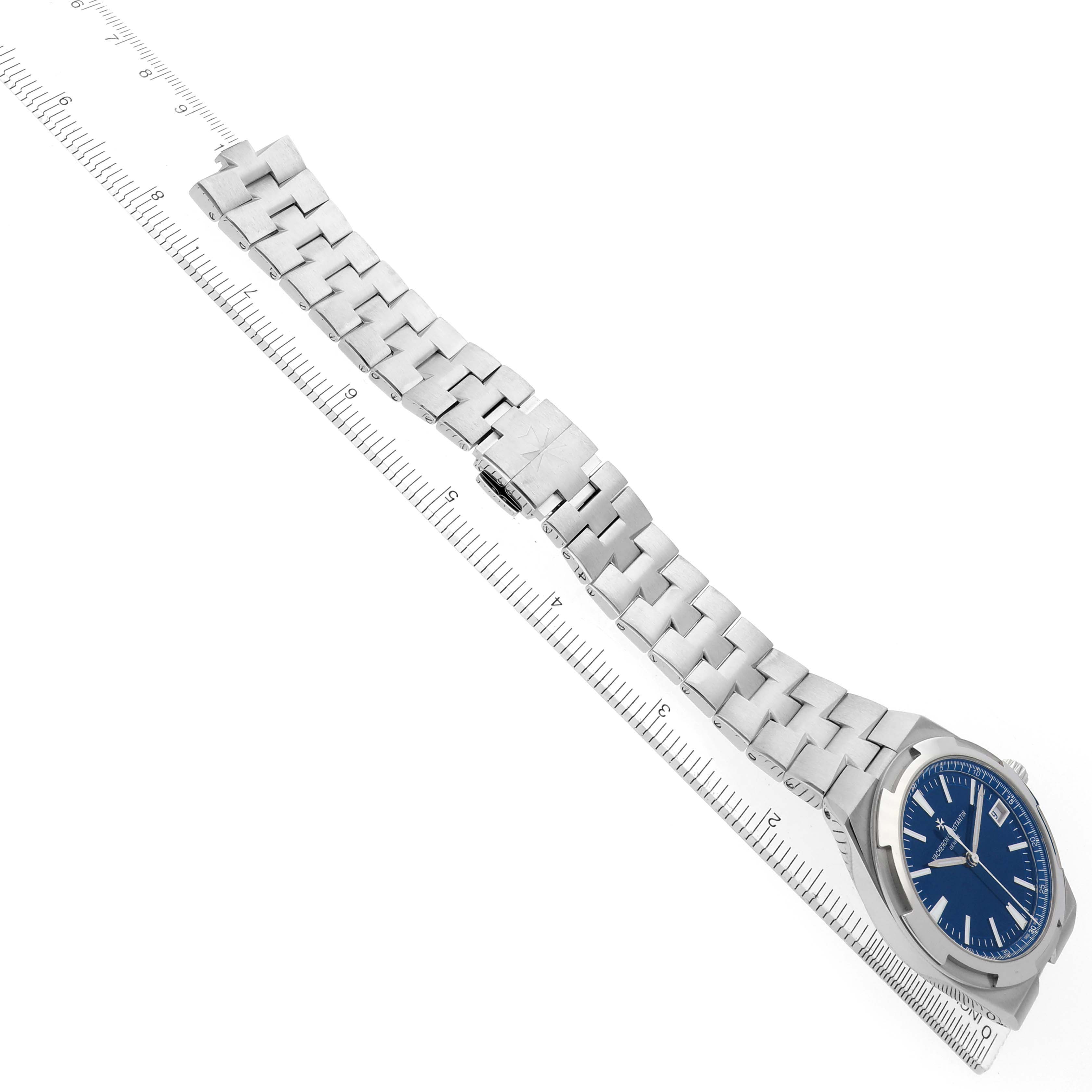 The Vacheron Constantin Overseas 4500V Mens Stainless Steel Blue Dial watch is shown at an angled view, displaying the blue dial, bracelet, and clasp over a ruler.