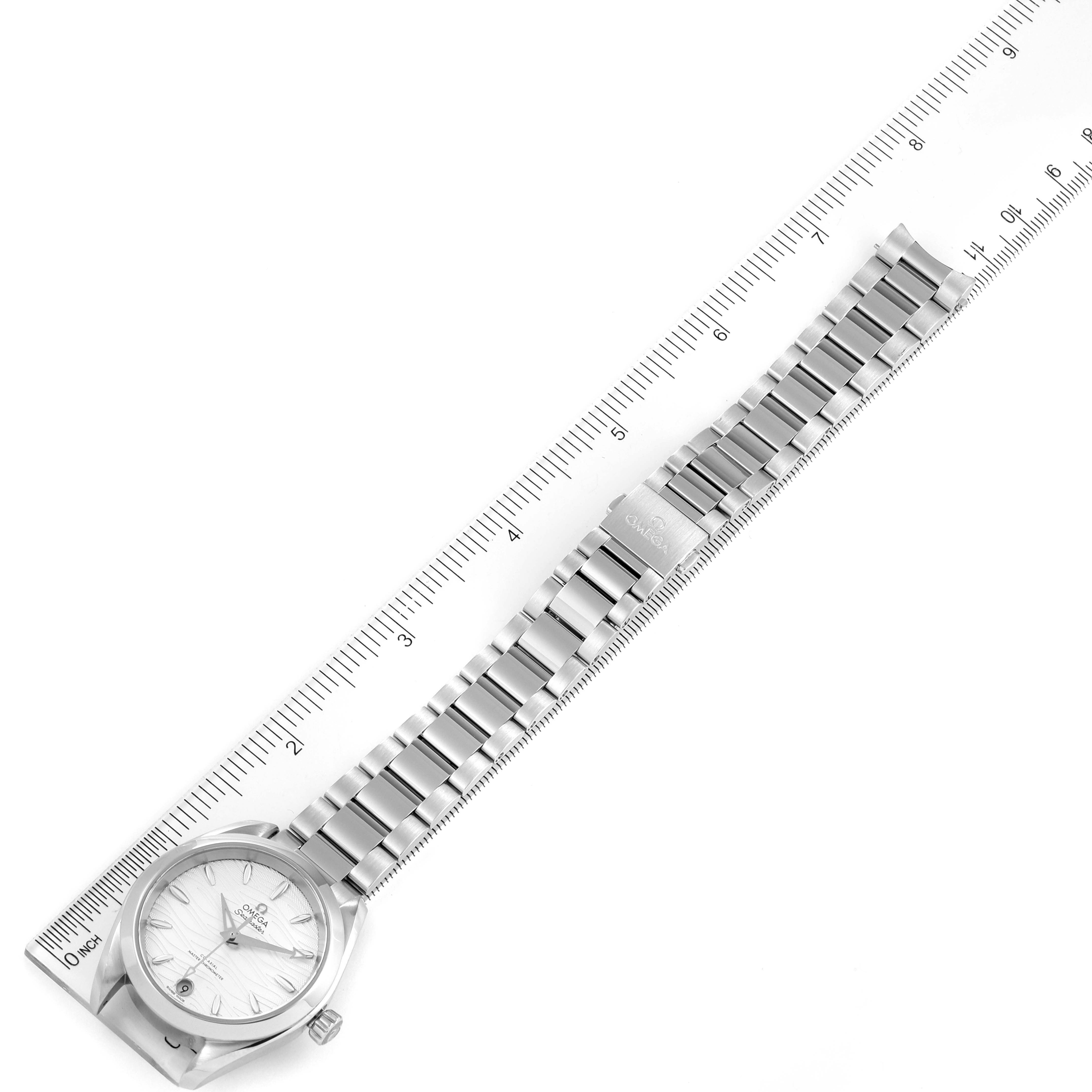 The Omega 220.10.34.20.02.002 Women
s Stainless Steel Silver Dial 220.10.34.20.02.002 Women
s Stainless Steel Silver Dial Seamaster Aqua Terra Steel Ladies Watch 220.10.34.20.02.002 is shown from an overhead angle, with the watch lying flat on a ruler.