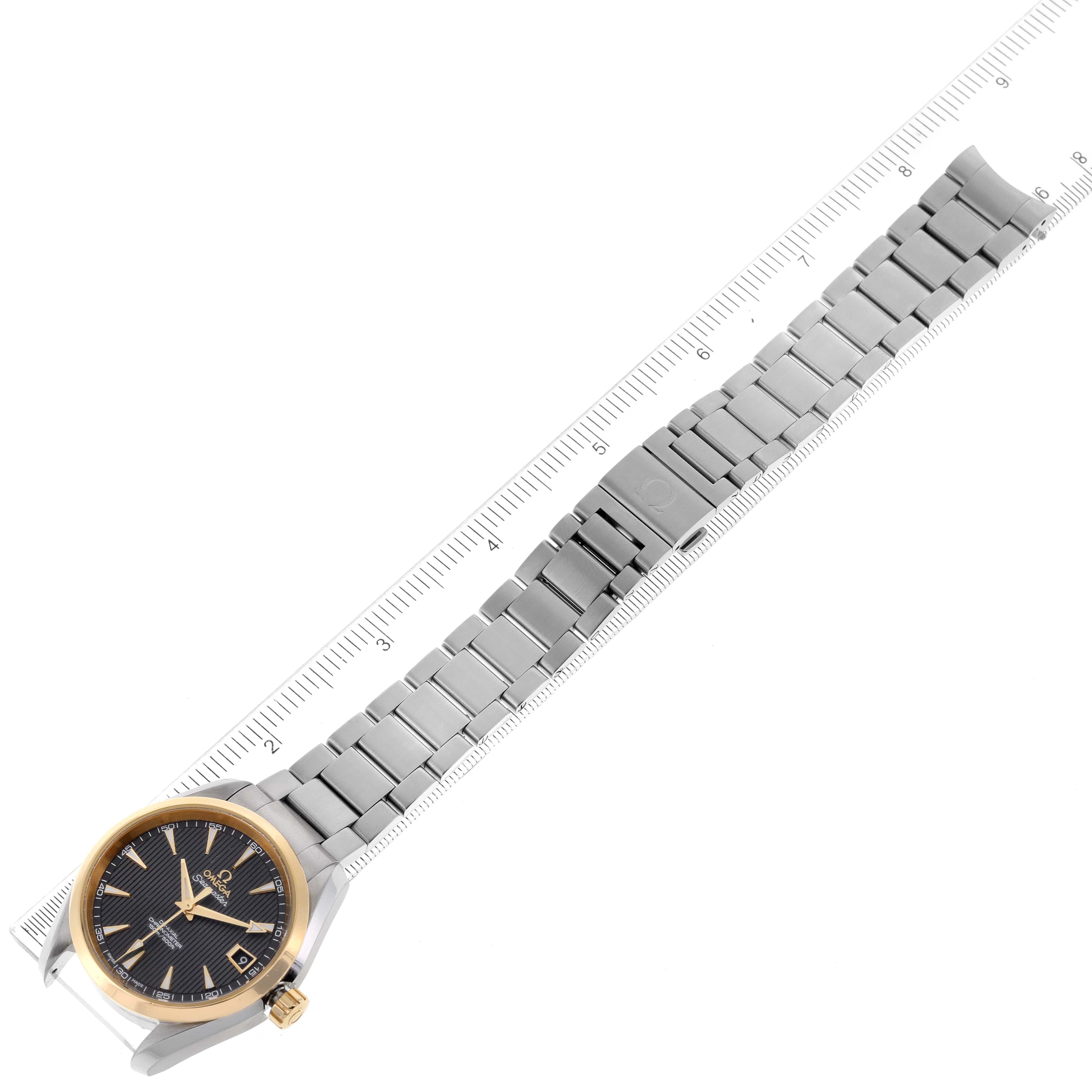 The Omega Aqua Terra 231.20.39.21.06.004 Men's Steel and Gold (two tone) Grey Dial 231.20.39.21.06.004 Men's Steel and Gold (two tone) Grey Dial watch is shown from a top-down angle, including its face, bracelet, and clasp, alongside a ruler for scale.
