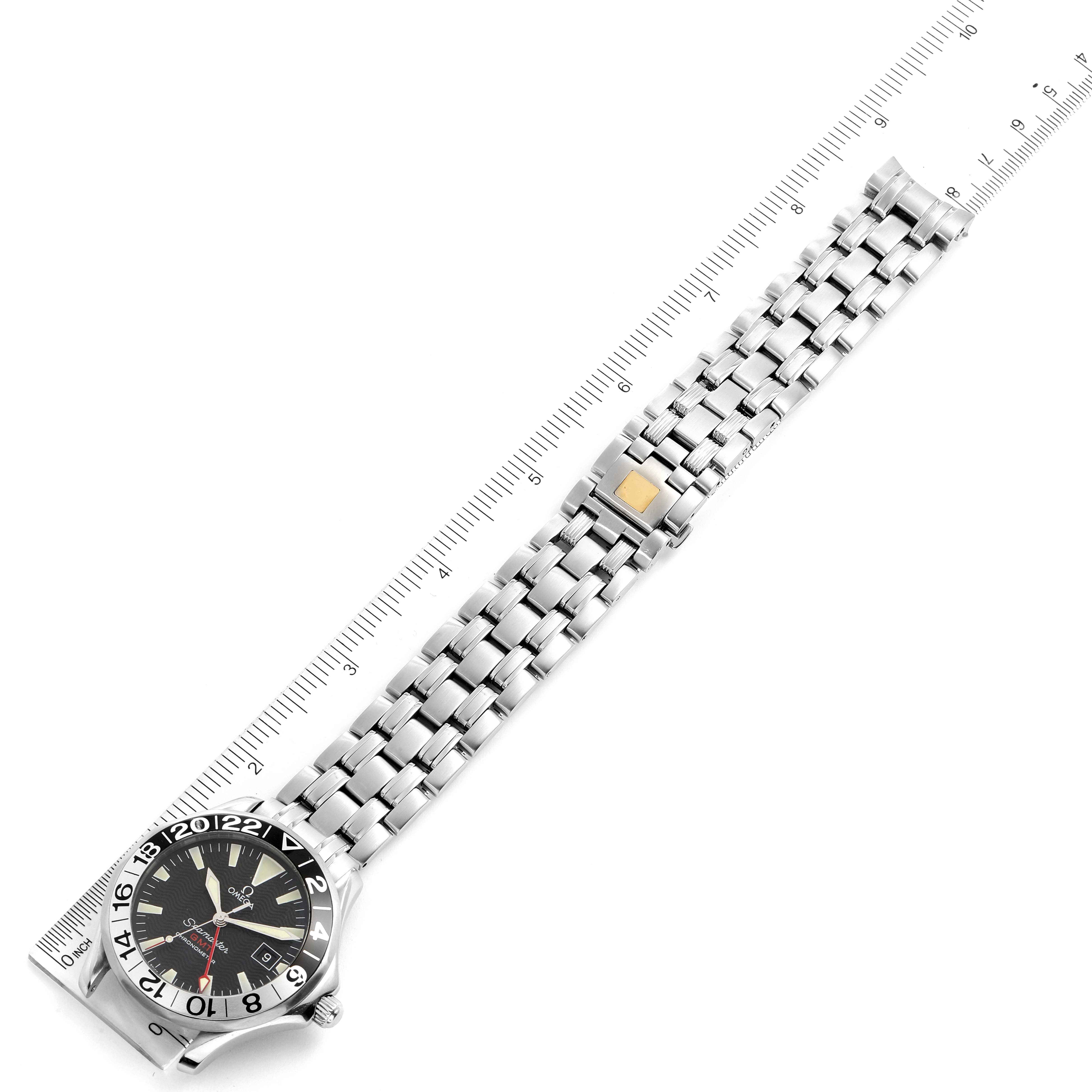 This image shows the Omega Seamaster 2534.50.00 Men
s Stainless Steel Black Dial 2534.50.00 Men
s Stainless Steel Black Dial watch laid flat with its metal bracelet extended, next to a measuring scale.
