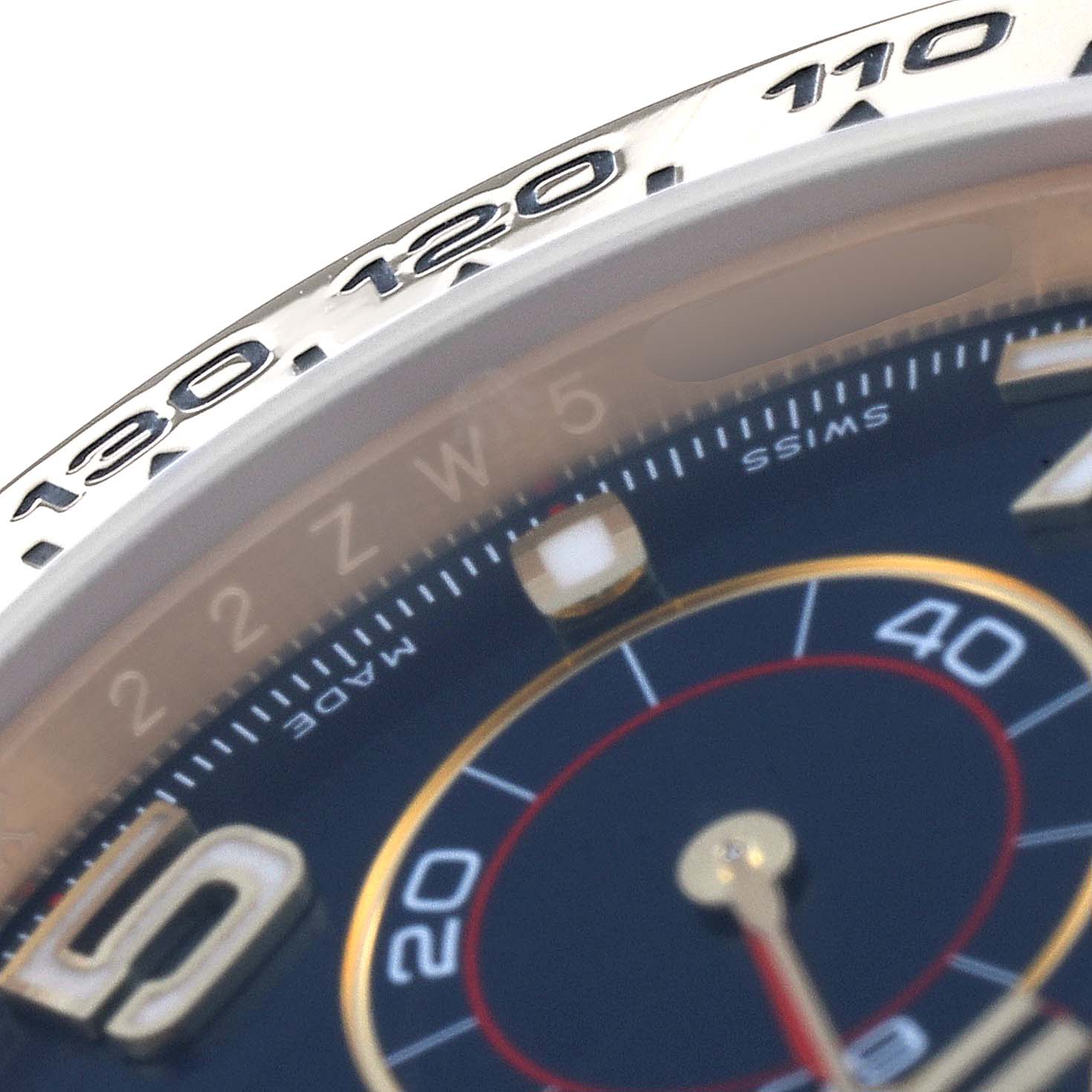 This close-up angle of the Rolex Daytona 116518 Men's Yellow Gold Blue Dial 116518 Men's Yellow Gold Blue Dial model shows parts of the dial and the tachymeter bezel.