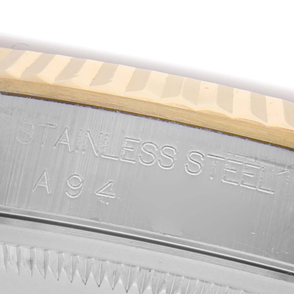 The image shows a close-up of the stainless steel bezel edge with fluted details and engraved text on a Rolex Datejust 16233 Men's Steel and Gold (two tone) Champagne Dial 16233 Men's Steel and Gold (two tone) Champagne Dial watch.
