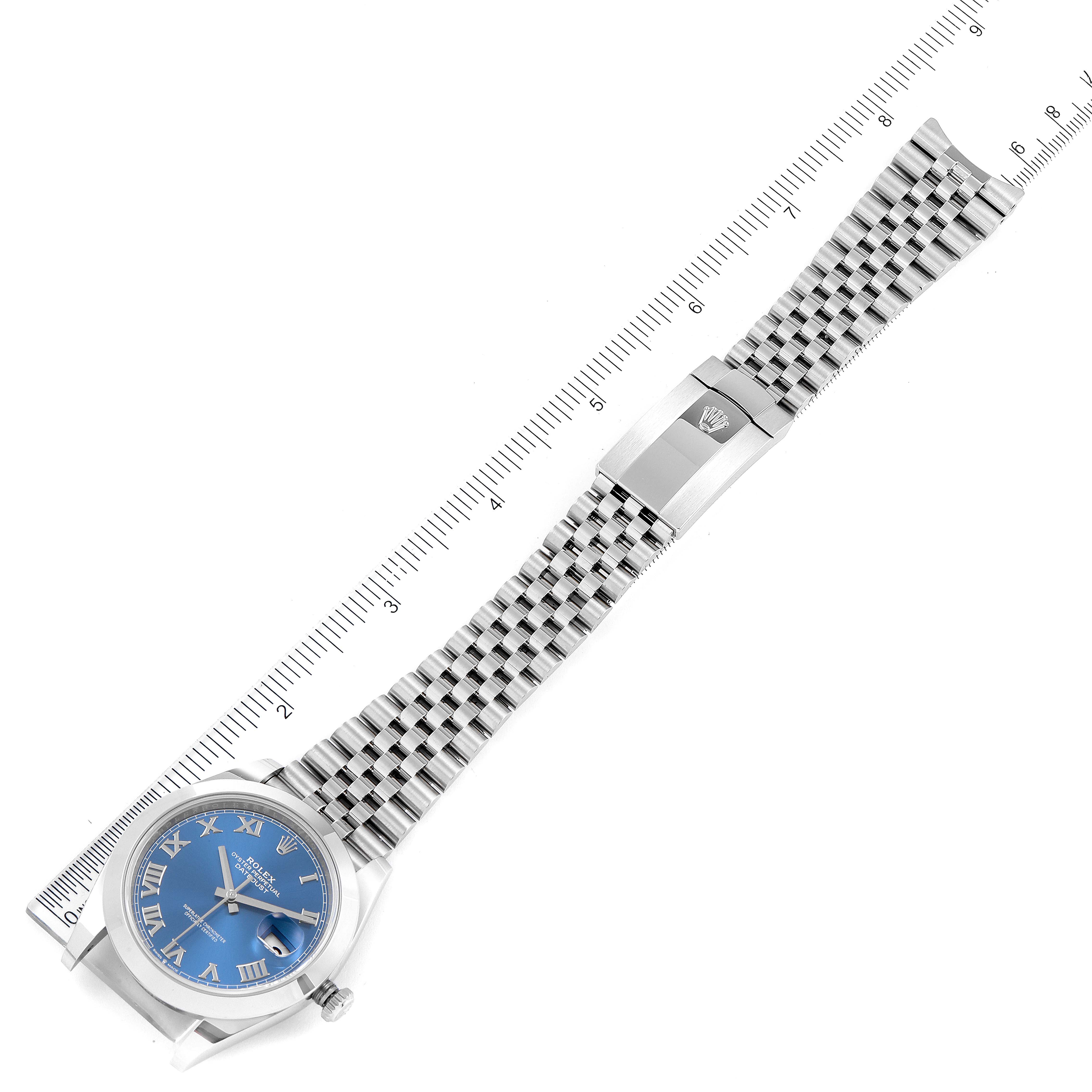 The image shows the Rolex Datejust 41 126300 Men
s Stainless Steel Blue Dial 126300 Men
s Stainless Steel Blue Dial model watch laid flat, highlighting its blue dial, Jubilee bracelet, and clasp with a ruler for scale.