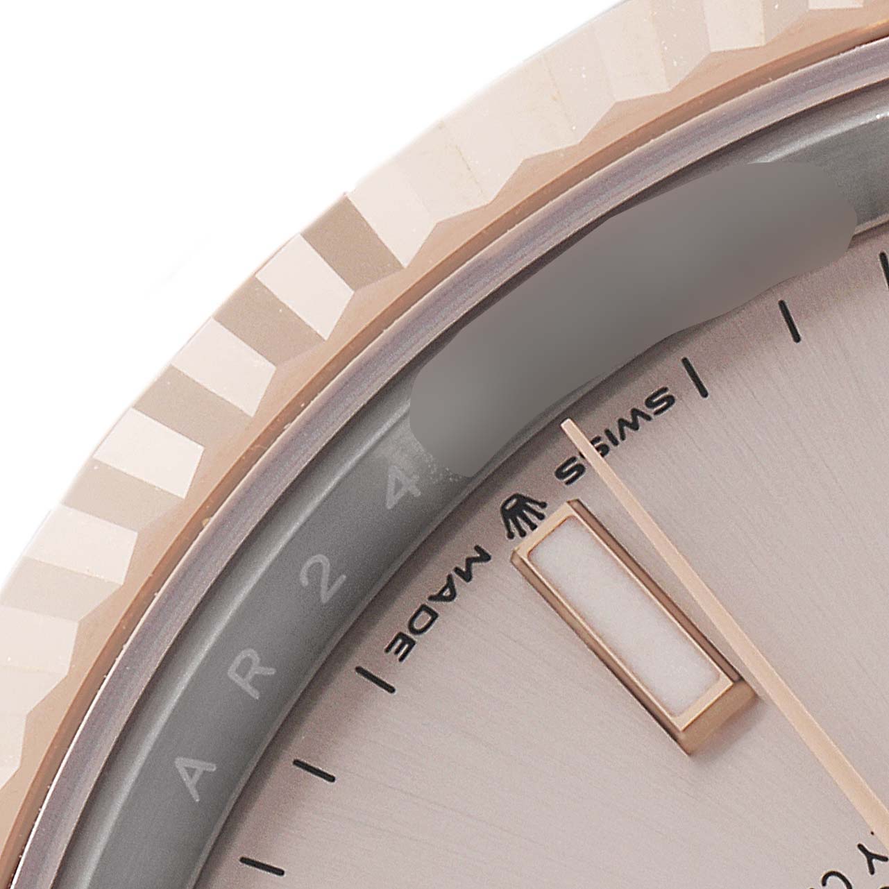 This close-up image of a Rolex Datejust 41 126331 Men's Steel and Gold (two tone) Beige Dial 126331 Men's Steel and Gold (two tone) Beige Dial shows the fluted bezel, part of the dial, and an hour marker.